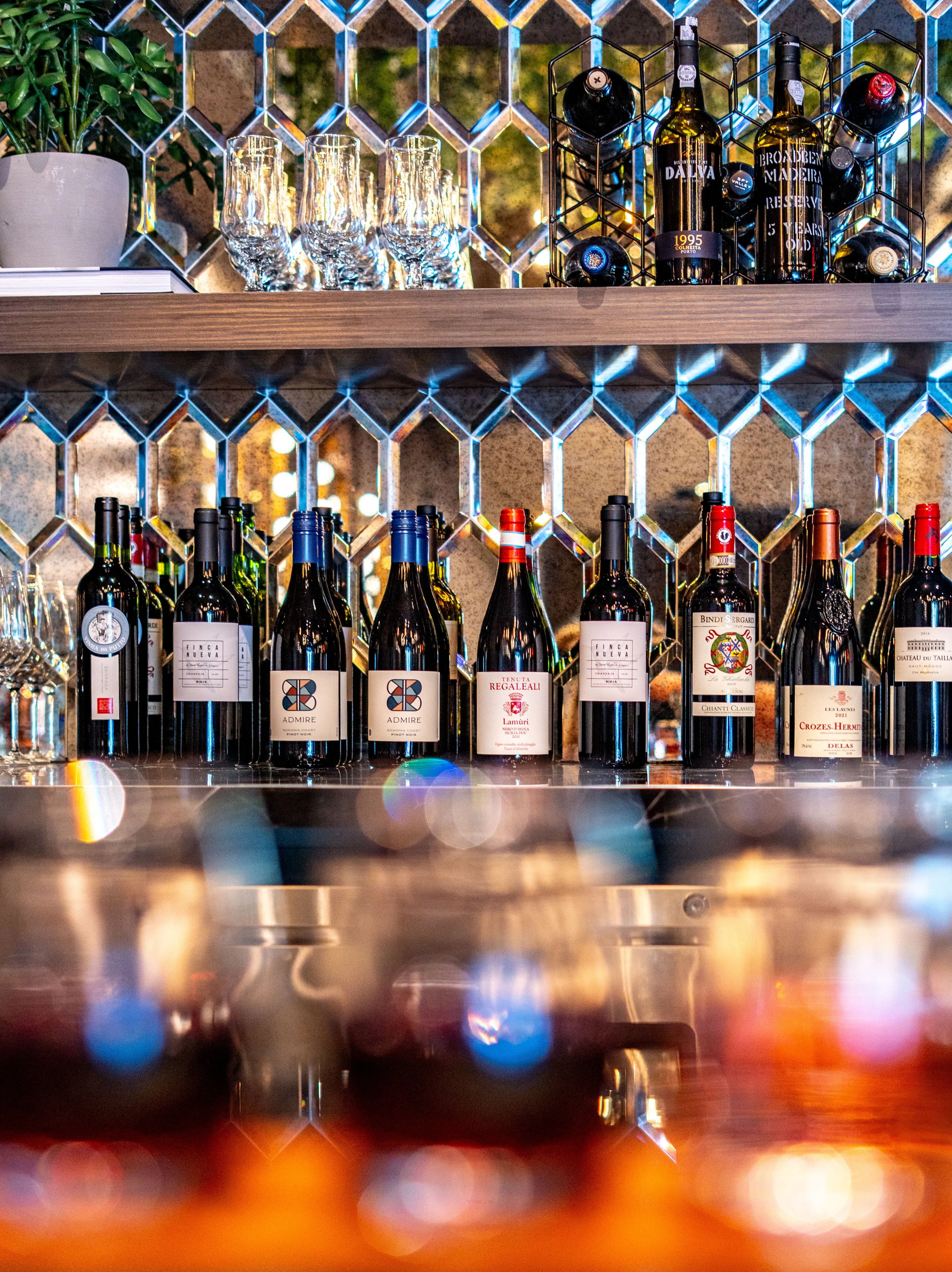 Commercial wine bar renovation in Belvedere-Tiburon designed by Marin interior designer Studio SQUIRE featuring Mirrored Backsplash and Wood Shelves