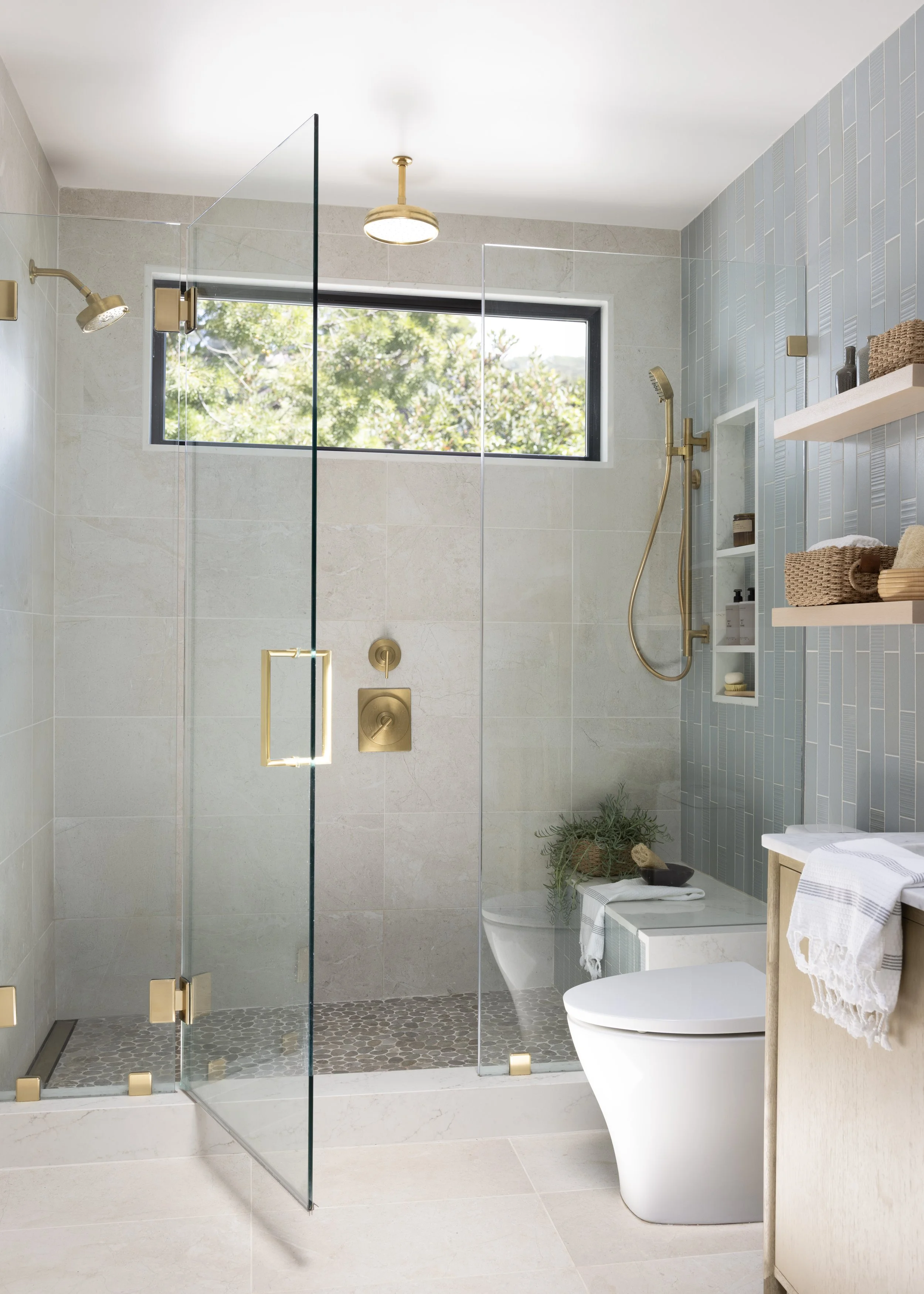 Primary Bathroom renovation in Mill Valley designed by Marin interior designer Studio SQUIRE featuring Blue Tile, Wood Shelves, and Brass Fixtures