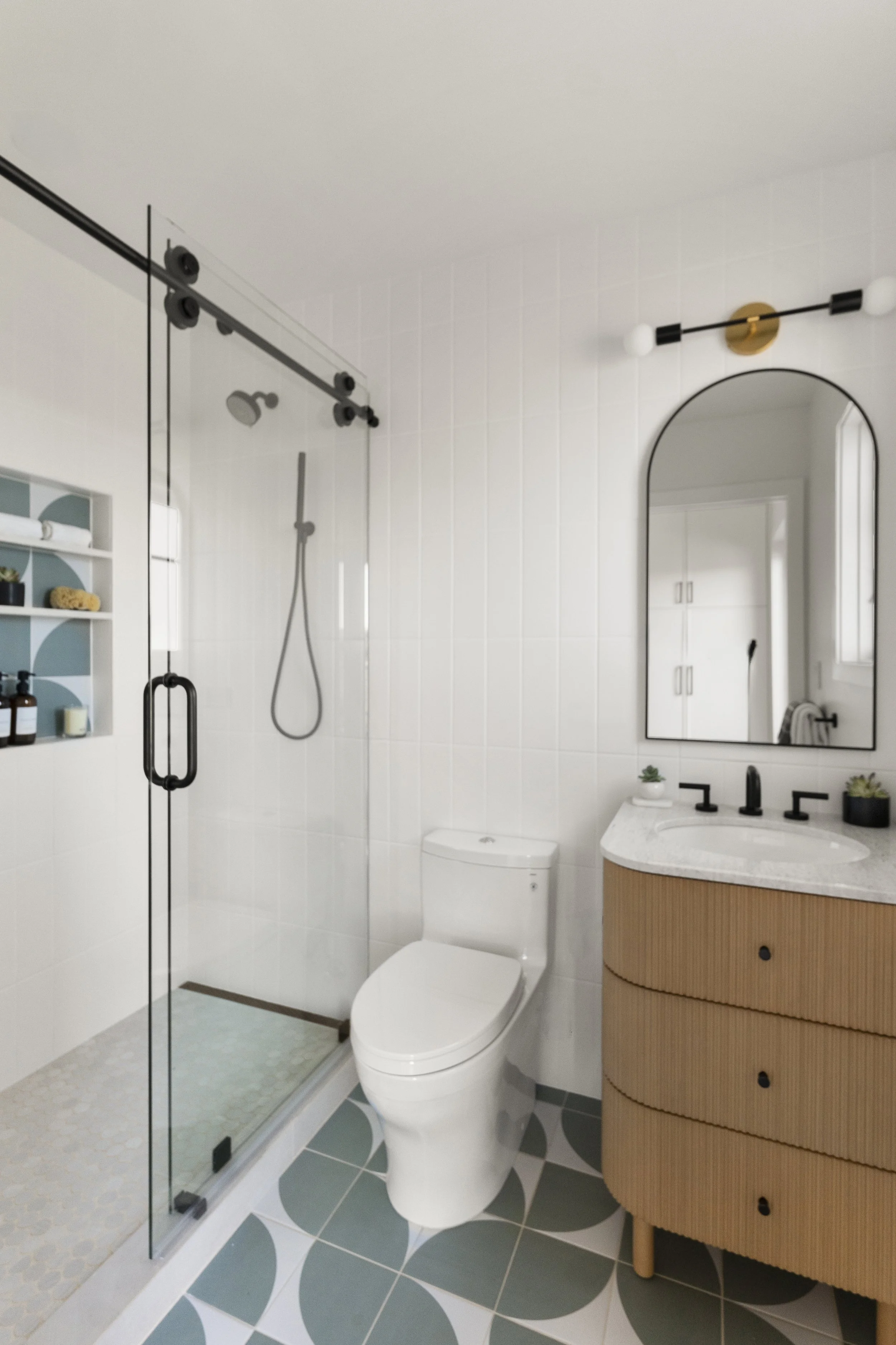 Kids bathroom renovation in Tiburon designed by Marin interior designer Studio SQUIRE featuring playful modern tile design, white oak vanity, and matte black hardware and plumbing fixtures.