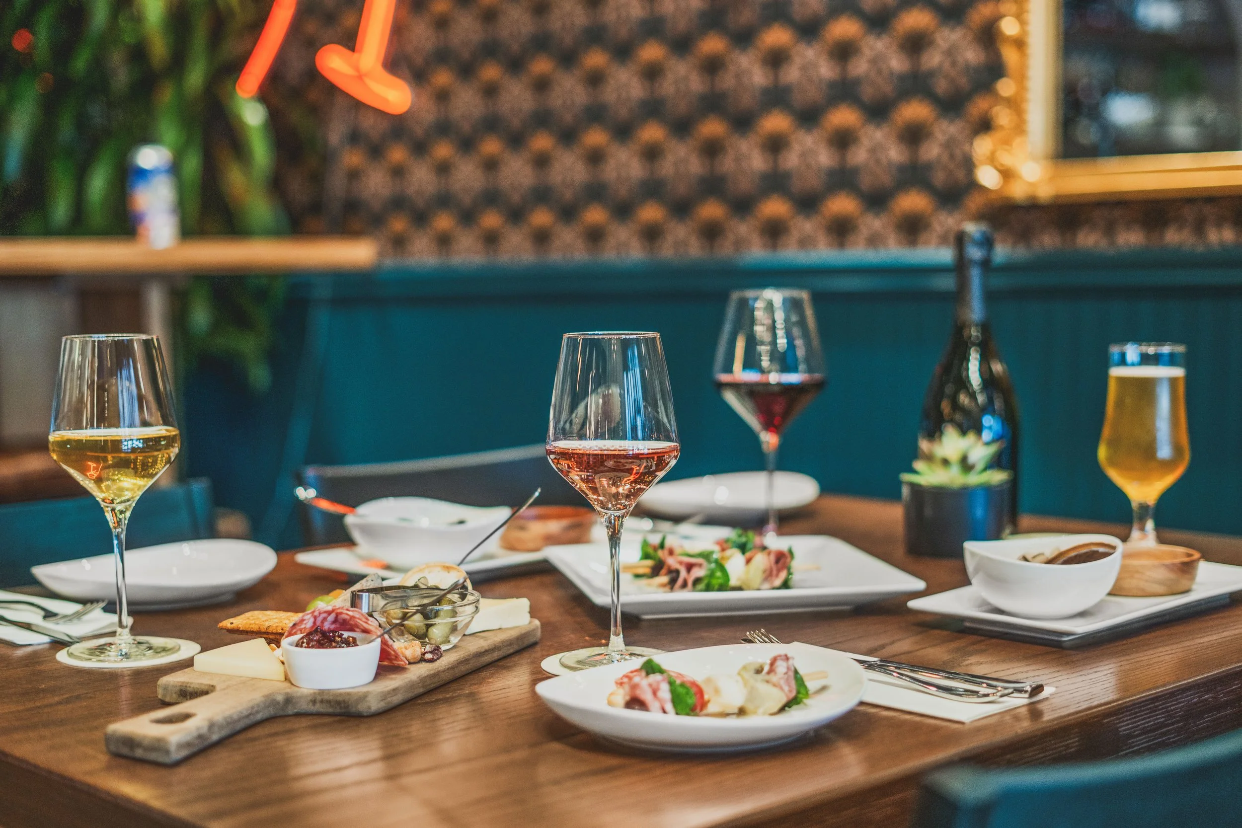 Commercial wine bar renovation in Belvedere-Tiburon designed by Marin interior designer Studio SQUIRE featuring a Wood Table, Barstools, Patterned Wallpaper, and Wall Paneling