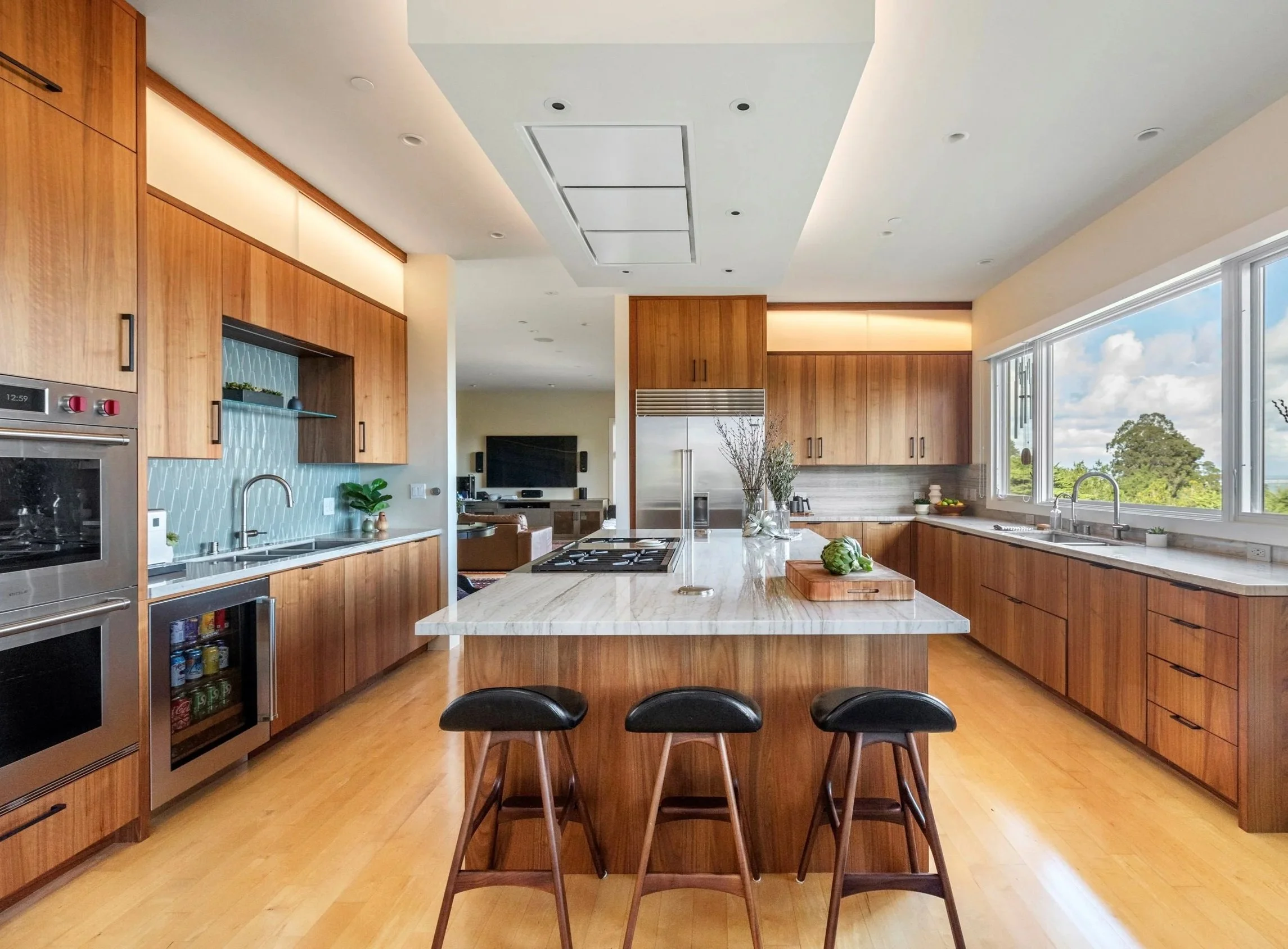 Kitchen renovation in Tiburon designed by Marin interior designer Studio SQUIRE featuring Wood Cabinets, Quartzite Countertops, Barstools, and Blue Backsplash