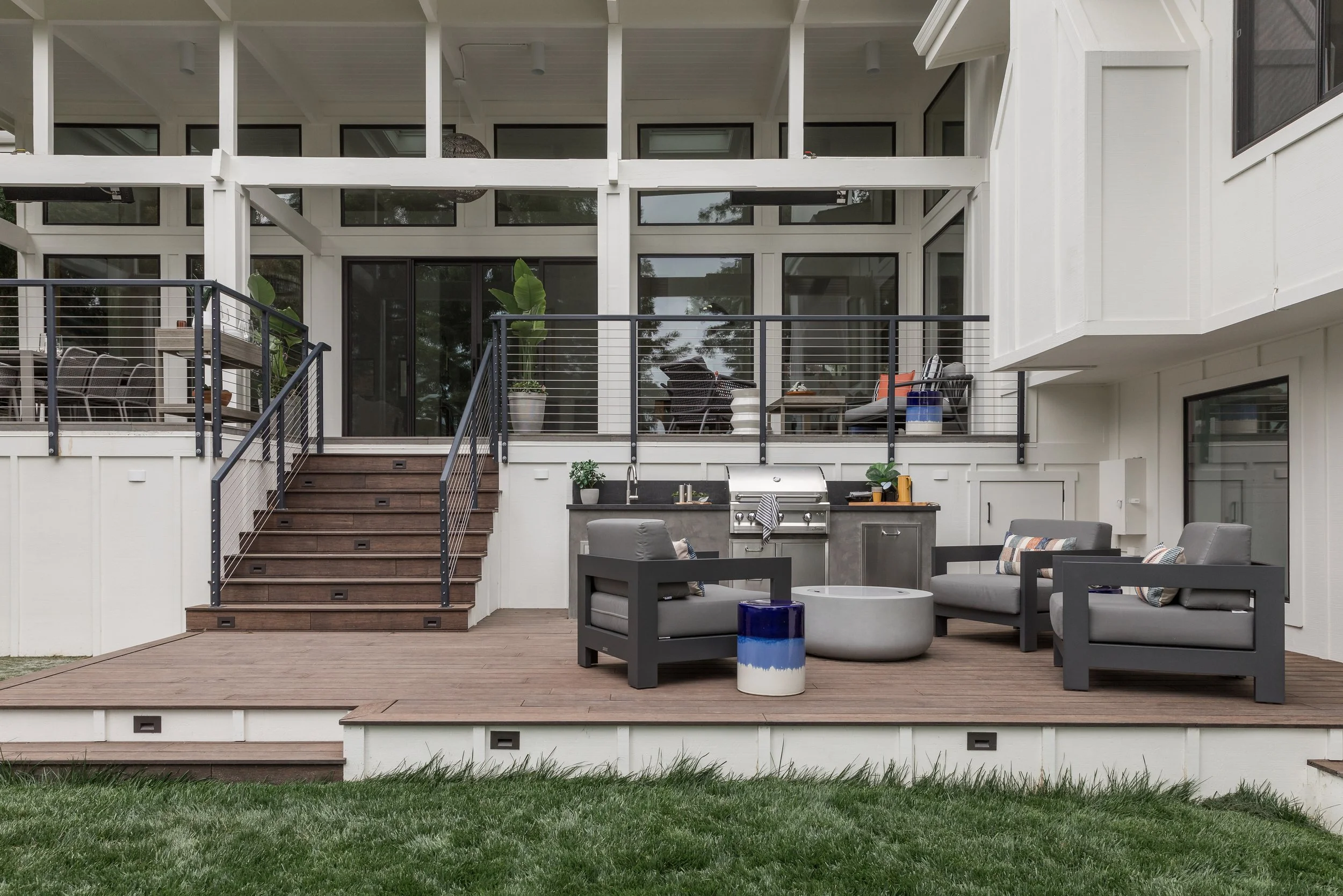 Outdoor renovation in Mill Valley designed by Marin interior designer Studio SQUIRE featuring a firepit, outdoor seating, built-in grill, sink, and trash drawer