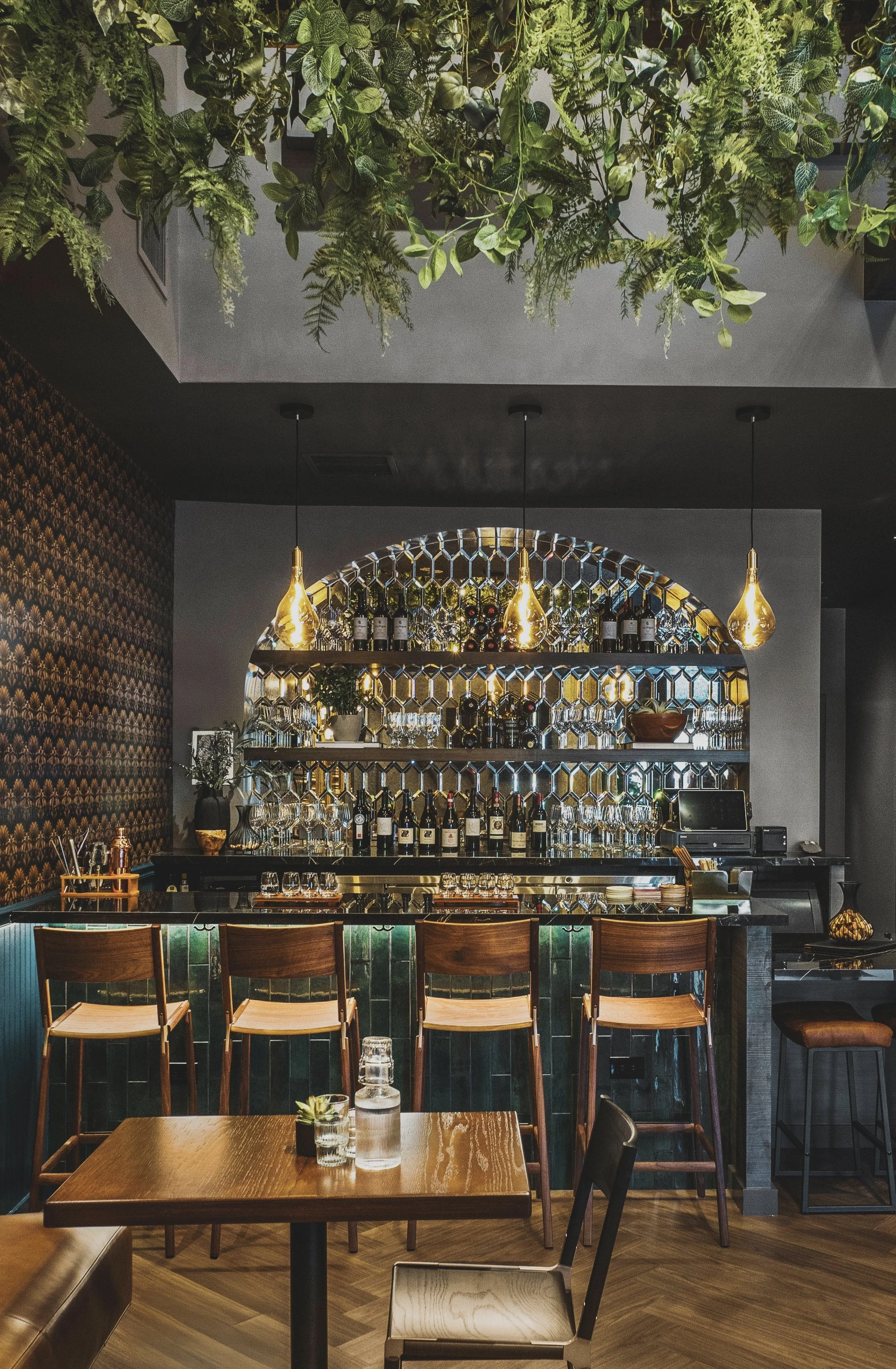 Commercial wine bar renovation in Belvedere-Tiburon designed by Marin interior designer Studio SQUIRE featuring Mirrored Backsplash, Wood Shelves, Wood Barstools, Patterned Wallpaper, and Green Tile