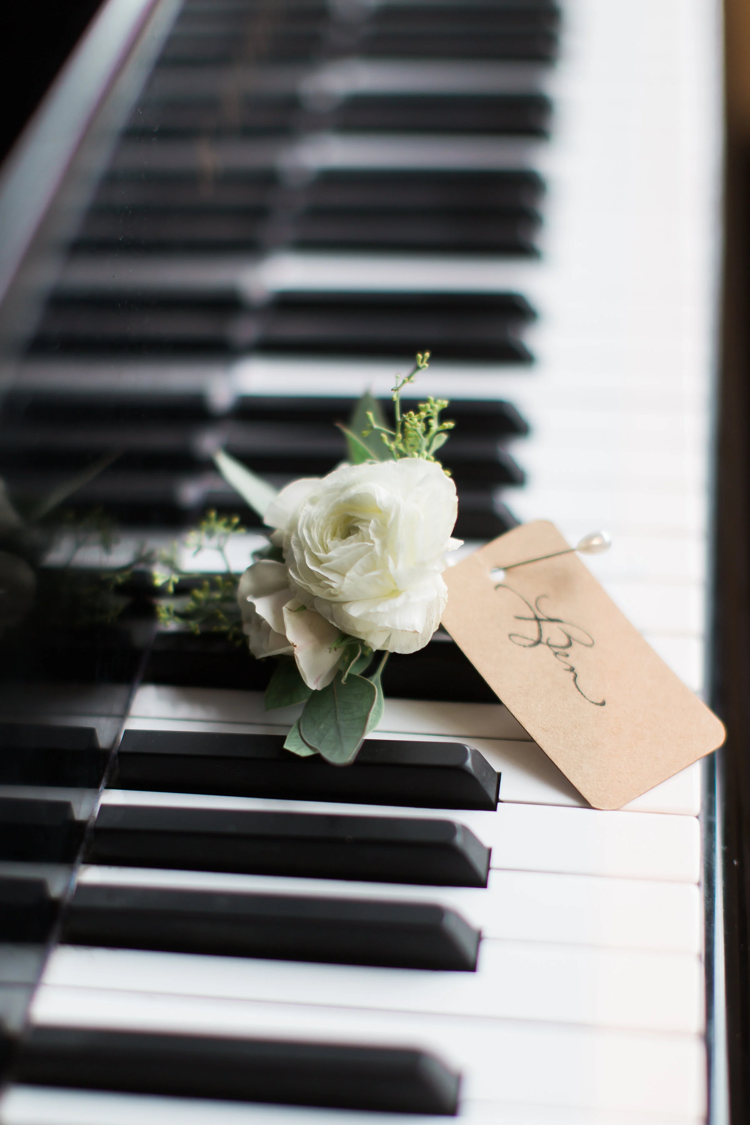 groom's boutonniere sits on a piano key