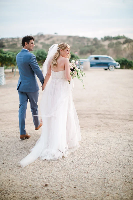 bride and groom walk to getaway car after ceremony