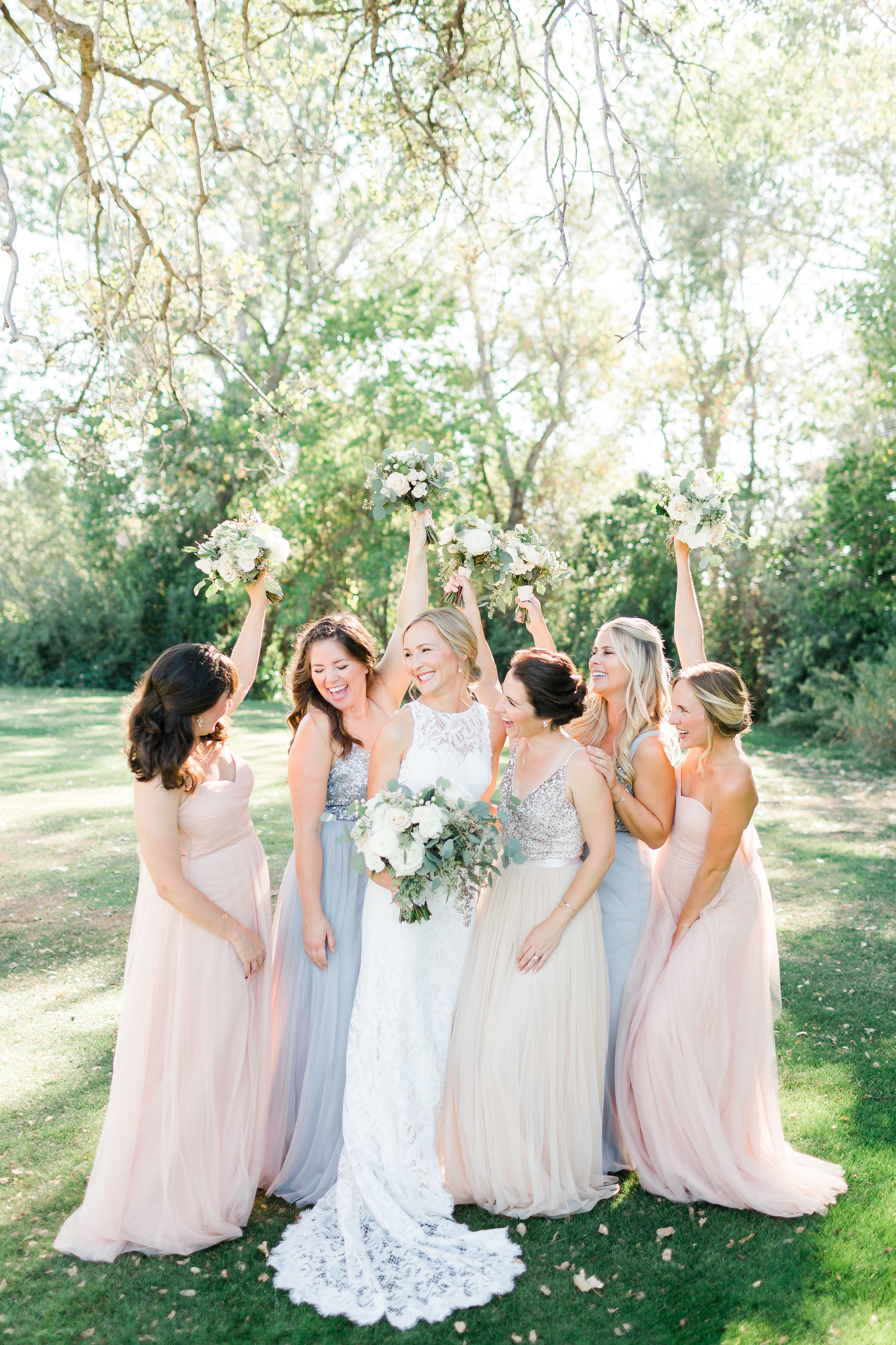 bride and bridesmaids celebrating in pastel dresses