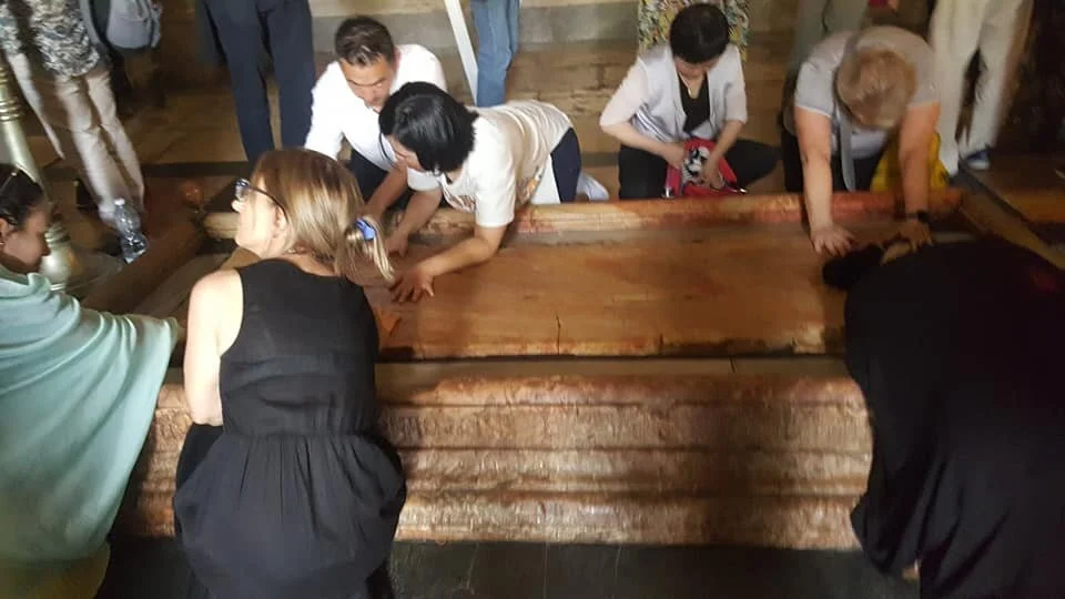 Devotees touch the Stone of Unction, Basilica of the Holy Sepulchre, 14 June 2019.