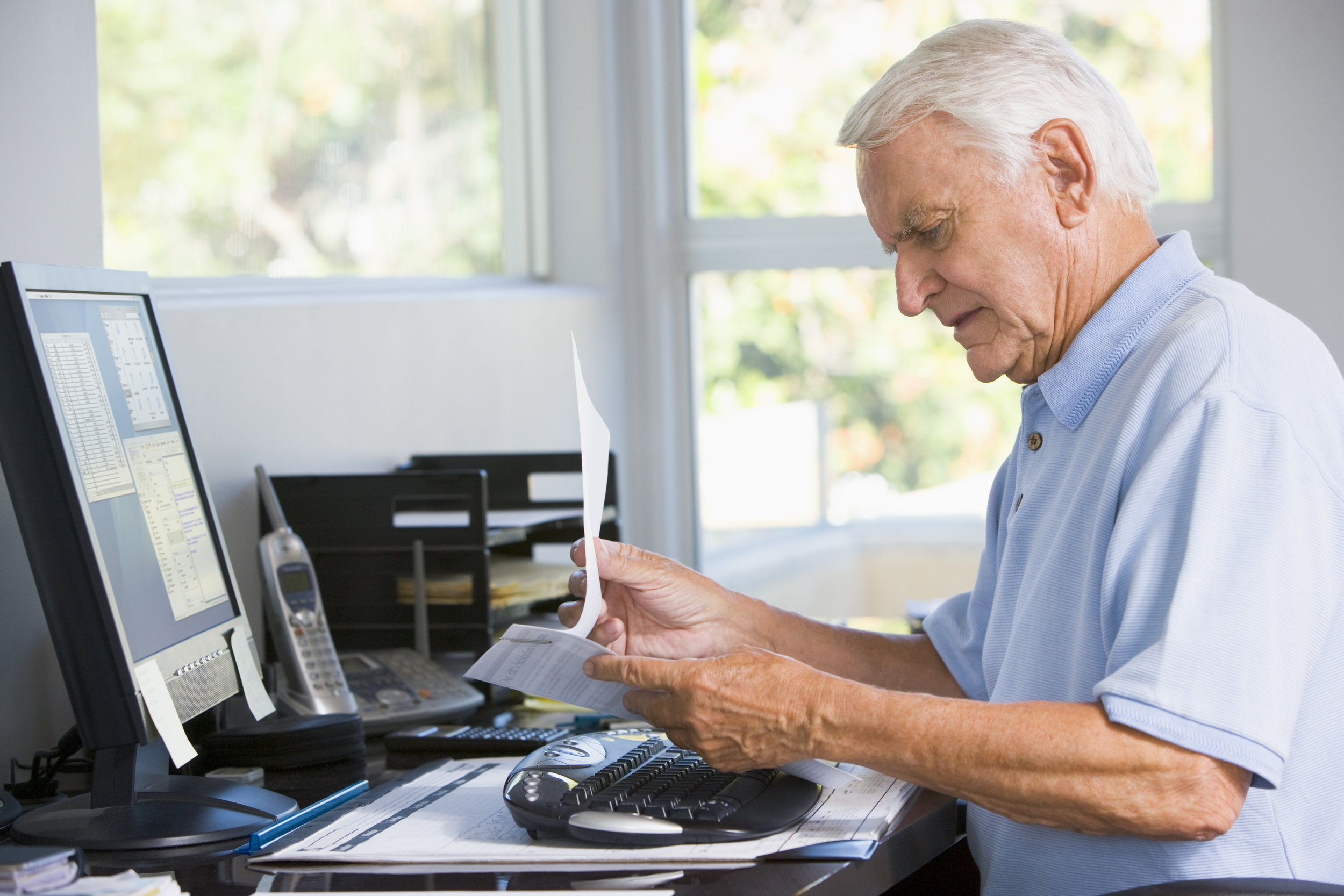 man-in-home-office-with-paperwork-and-computer_SYdgpFTRBi.jpg