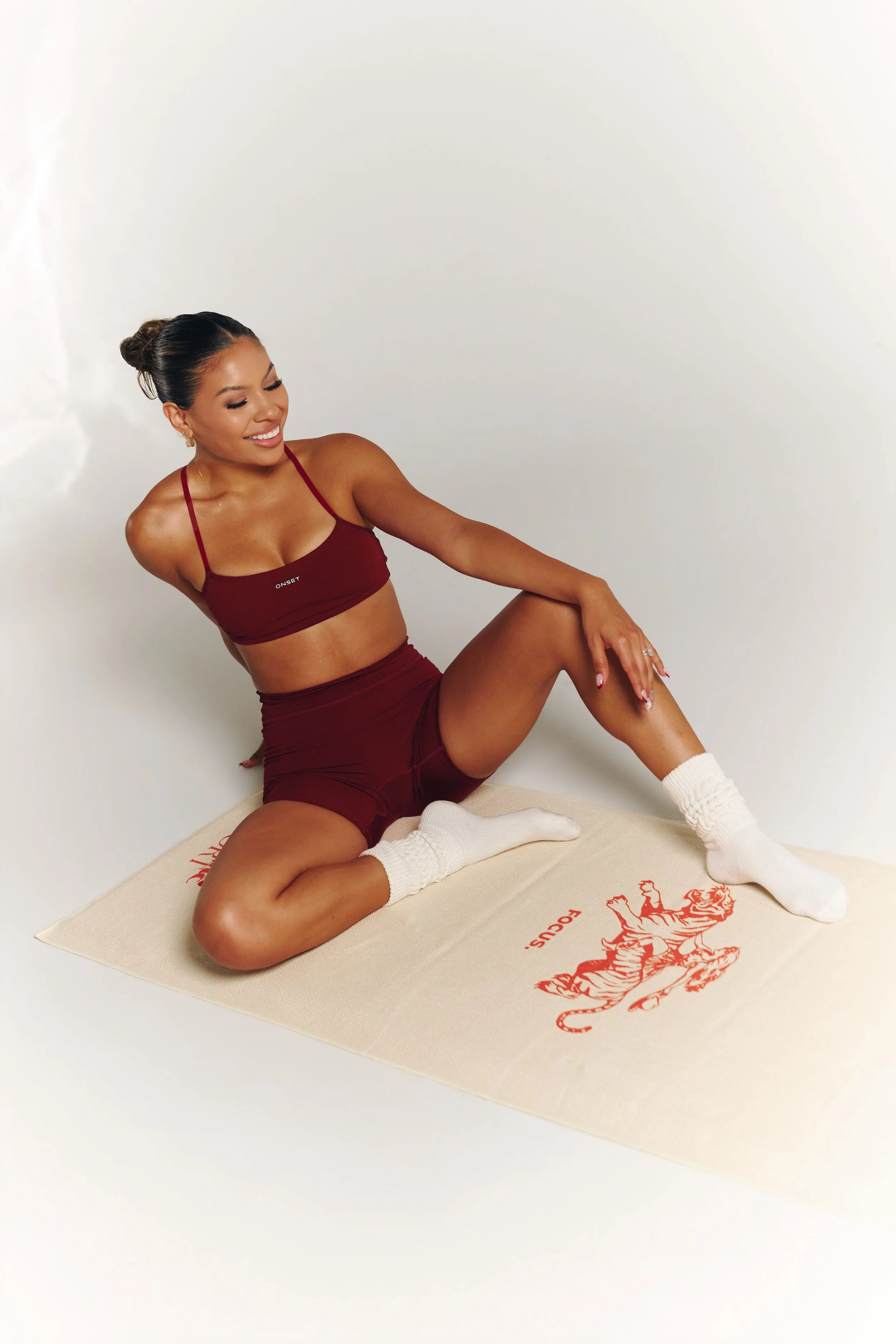 james-davis-commercial-photography-decidere-sport-burgundy-set-seated-side-pose.jpg