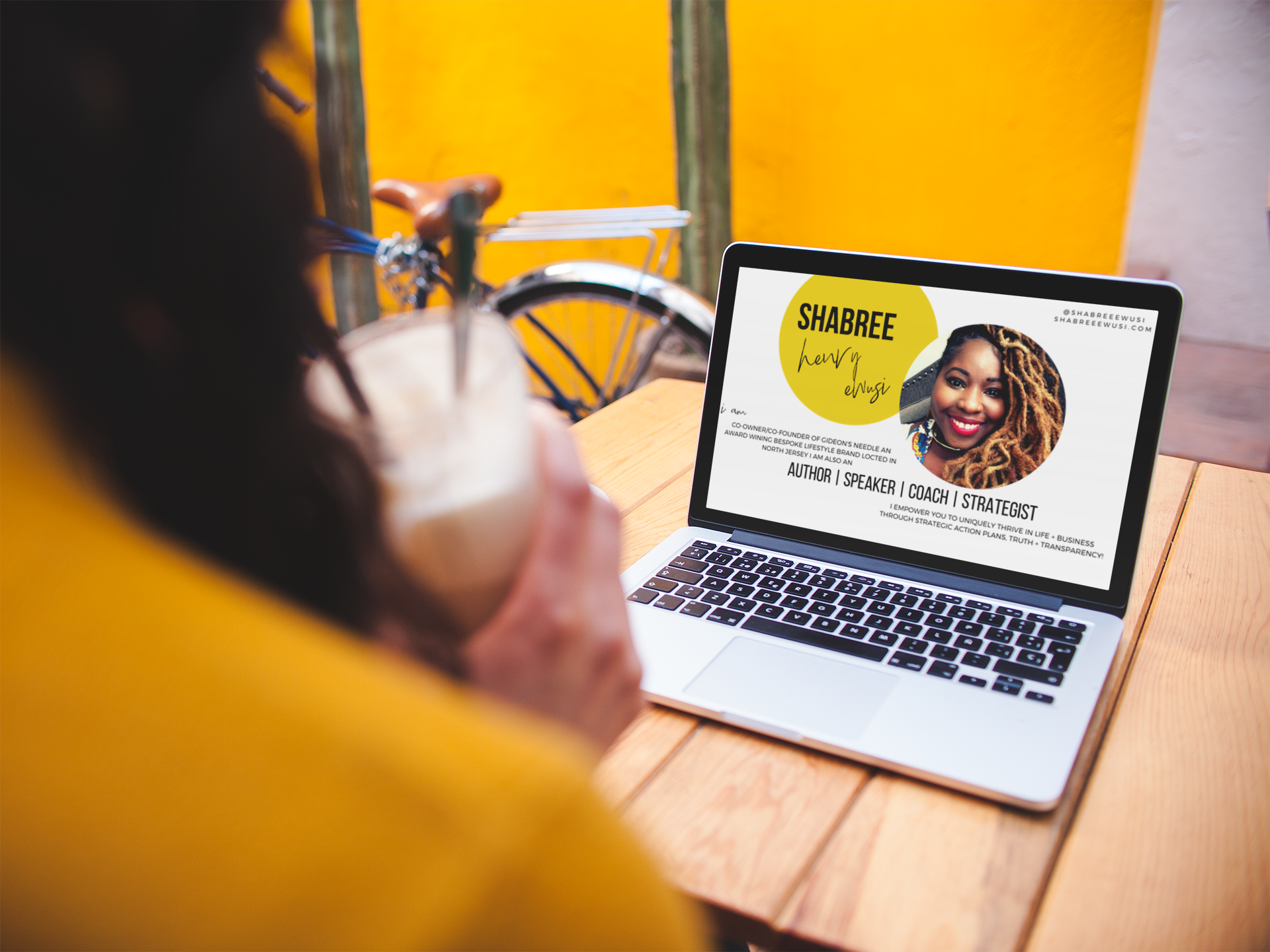 over-shoulder-mockup-of-a-woman-using-a-macbook-on-a-wooden-table-a19521.png
