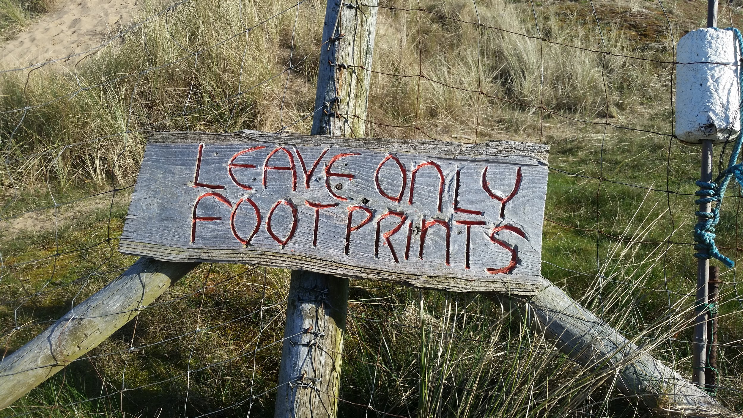 The 'Leave only Footprints' sign at Rhossili beach.