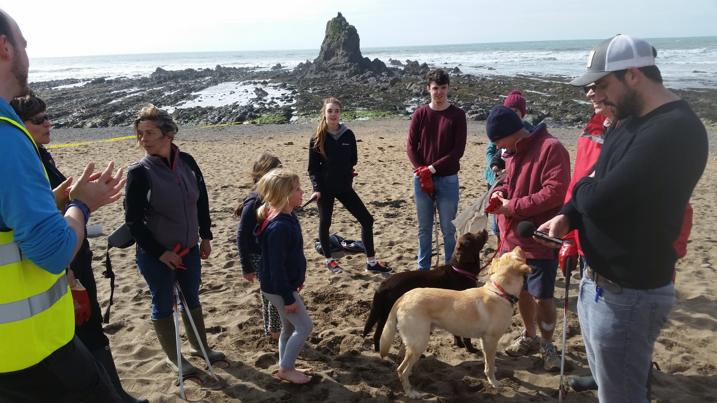 Pete with the Widemouth Task Force and their secret beach cleaning weapon - 2 x dogs at Widemouth Beach, Cornwall.