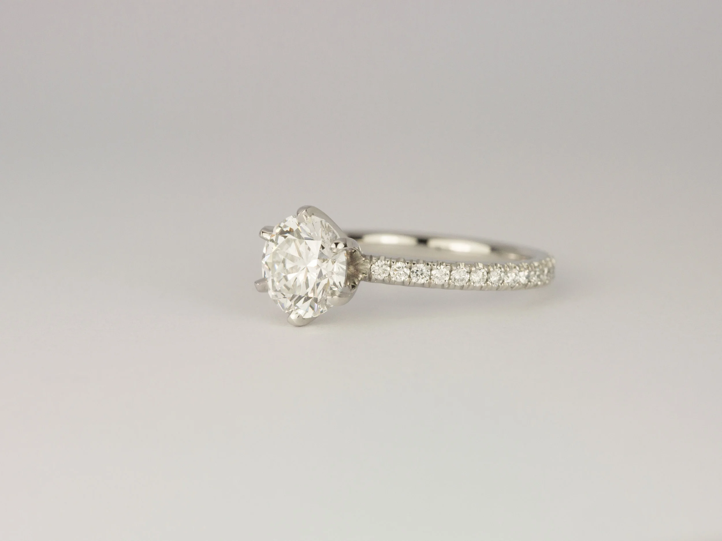 Six claw diamond and platinum engagement ring with a micro pavé diamond band