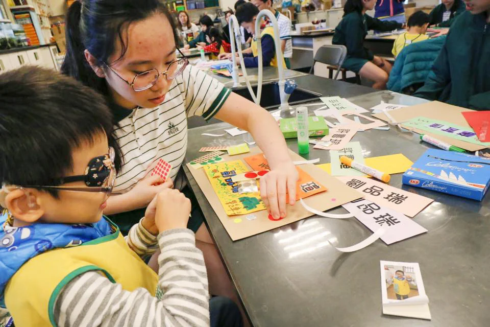 大姐姐與小天使同心協力完成海報創作