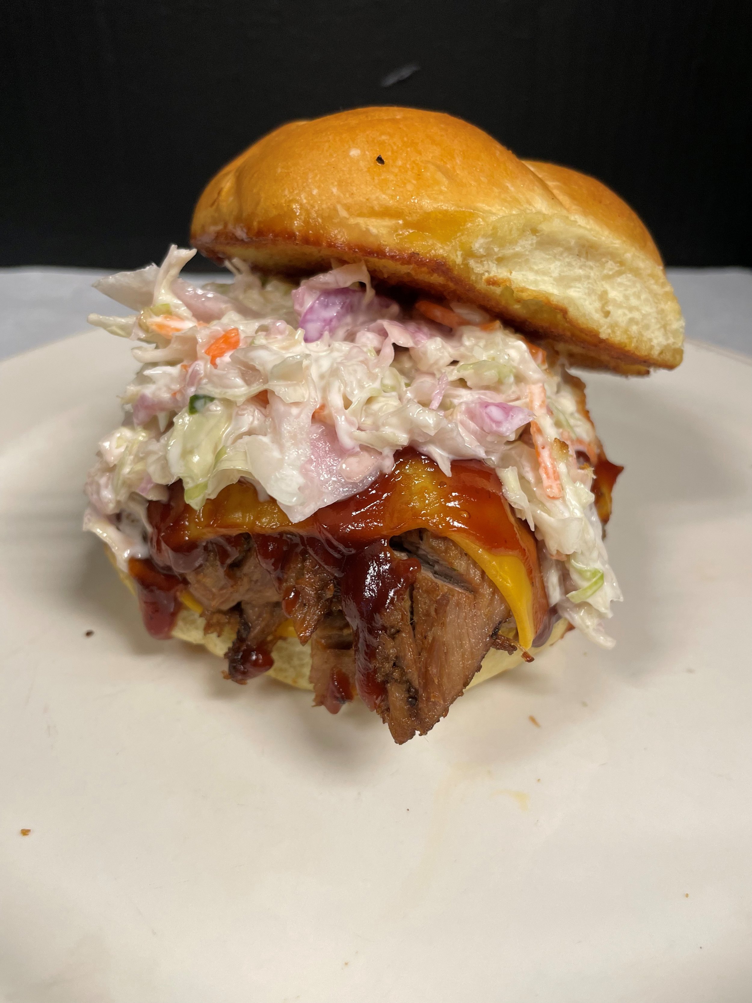 creamy coleslaw, american cheese, pulled pork, on toasted bun.jpg