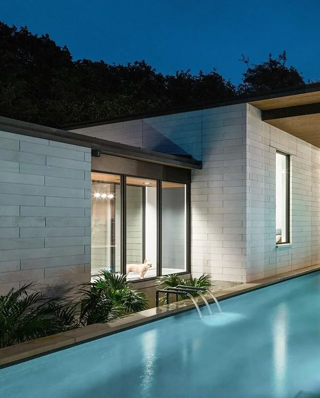 A short bridge (where the french bulldog is waiting) separates the master suite from the rest of the house in our #1700atx project. The private spaces in the house are set behind limestone walls and the dining area opens up to the pool. Always cool t