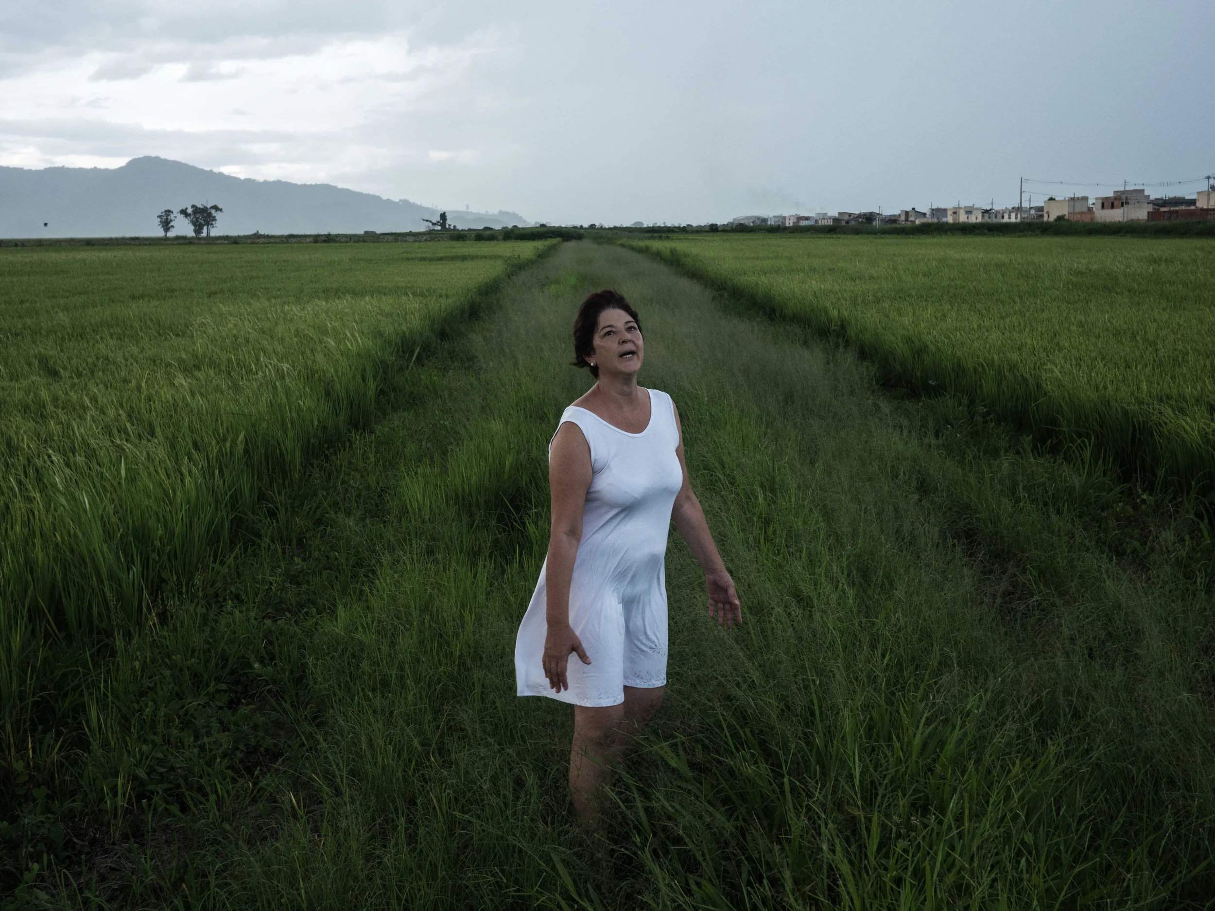 ISABELLA LANAVE www.isabellalanave.com | @isalanave Sueli de Fátima, my mother, in a rice field on January 15, 2018. When I was ten, my mother was diagnosed with bipolar disorder and it was only in the past two years that we started talking about our feelings surrounding it. Fatima became the subject of a long-term project centered on our relationship. Getting closer to each other became less painful than moving away. Kay Jamison, a psychiatrist with bipolar disorder, wrote in her book “Unquiet Mind” that the feeling about this illness is like a poem from Dylan Thomas: "The force that through the green fuse drives the flower/Drives my green age; that blasts the roots of trees/Is my destroyer." These words inspired us to make this photo.