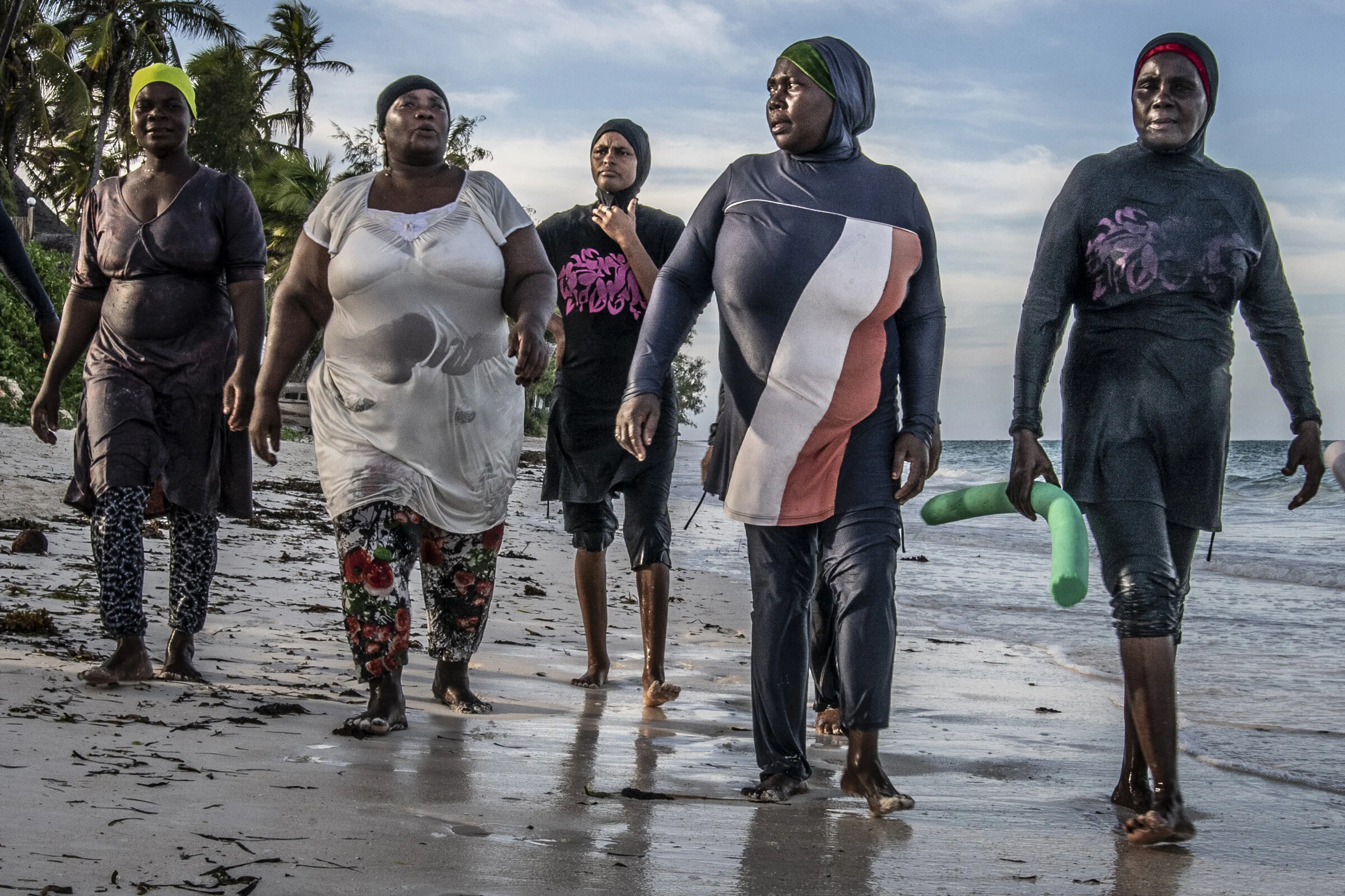 Swim instructor, octopus hunter, elder Bisichana (far right) walks on shore with her octopus hunter swim students after their lesson. Second from left is the wife of the village elder.
