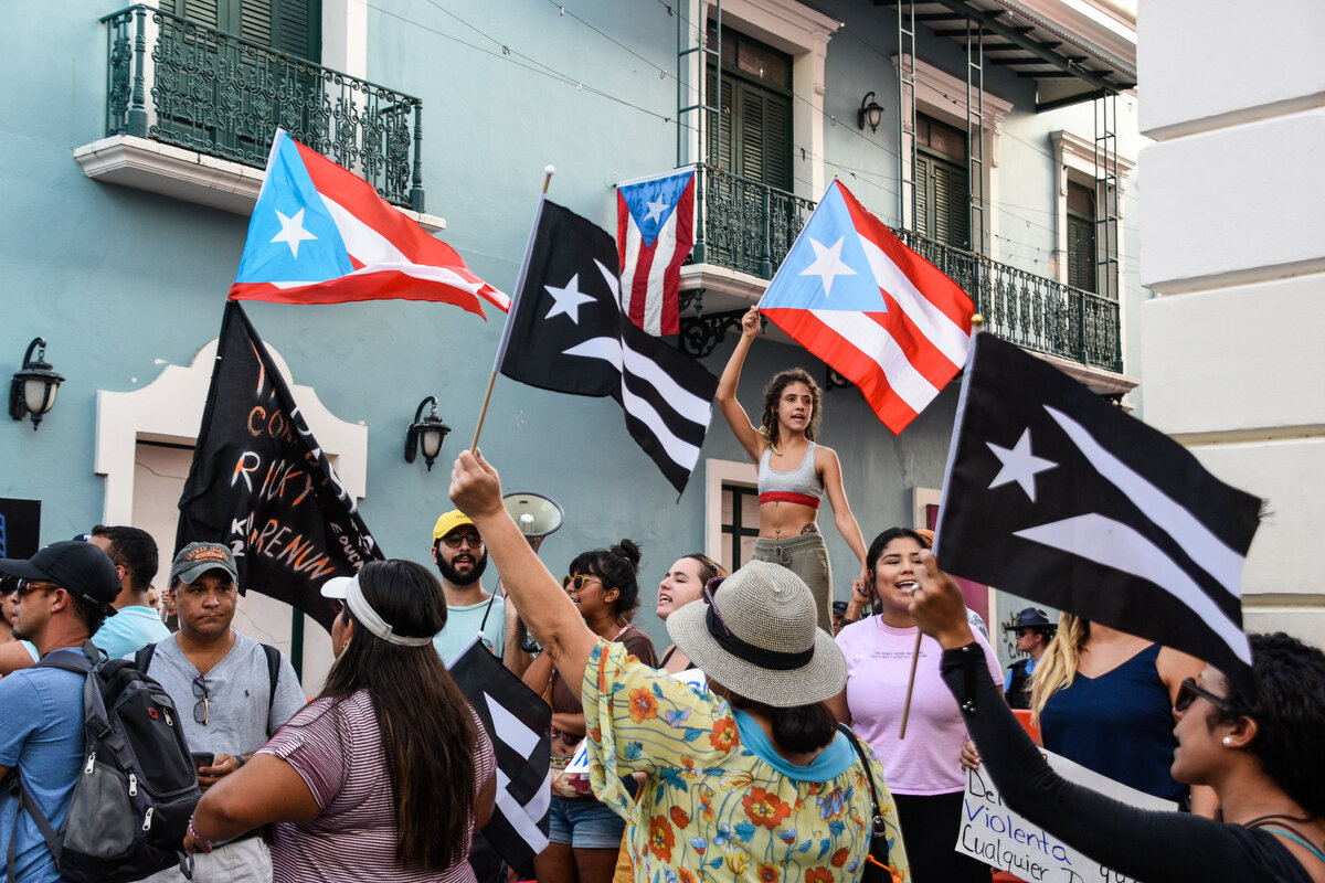 Demonstrators chant and wave Puerto Rican flags during the fourth day of pr...