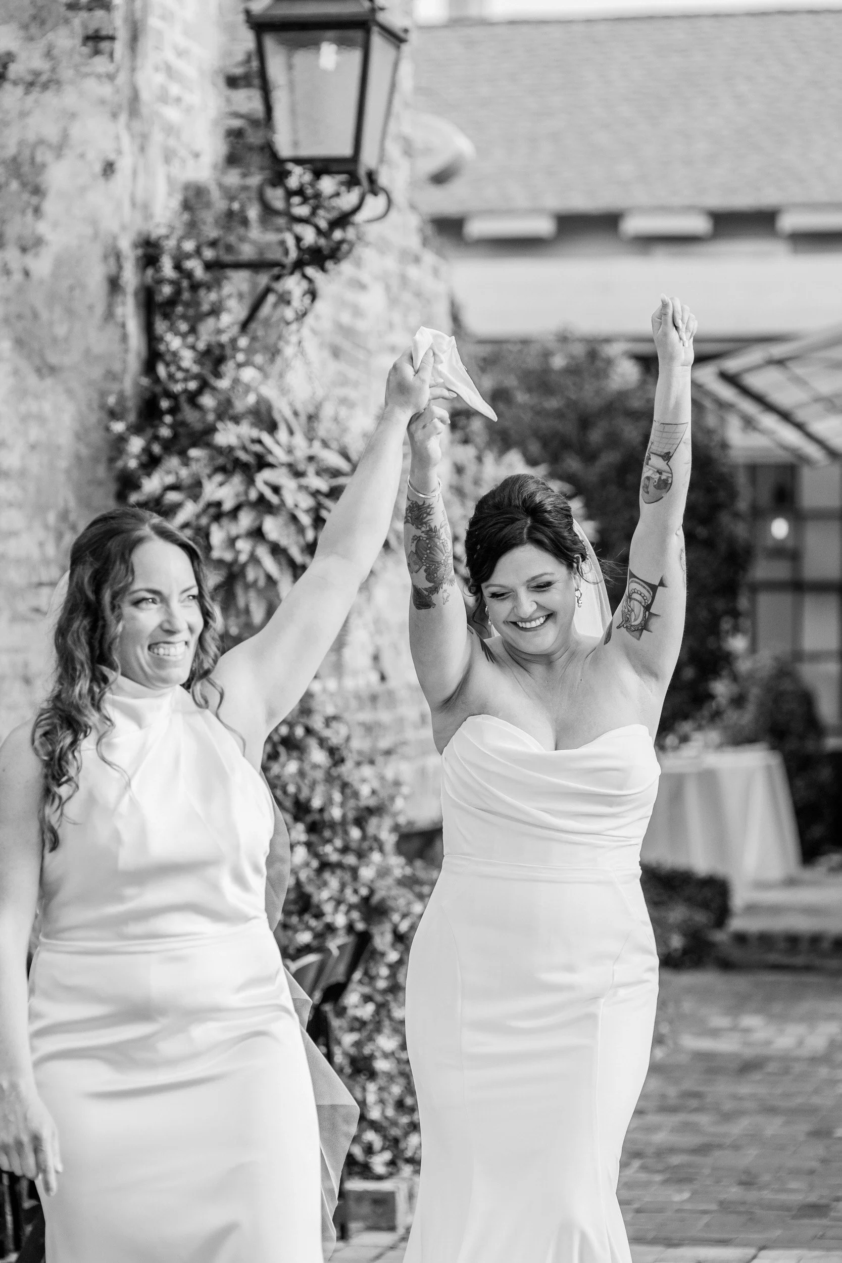 Newlyweds smiling and holding their hands up as they walk back up the aisle