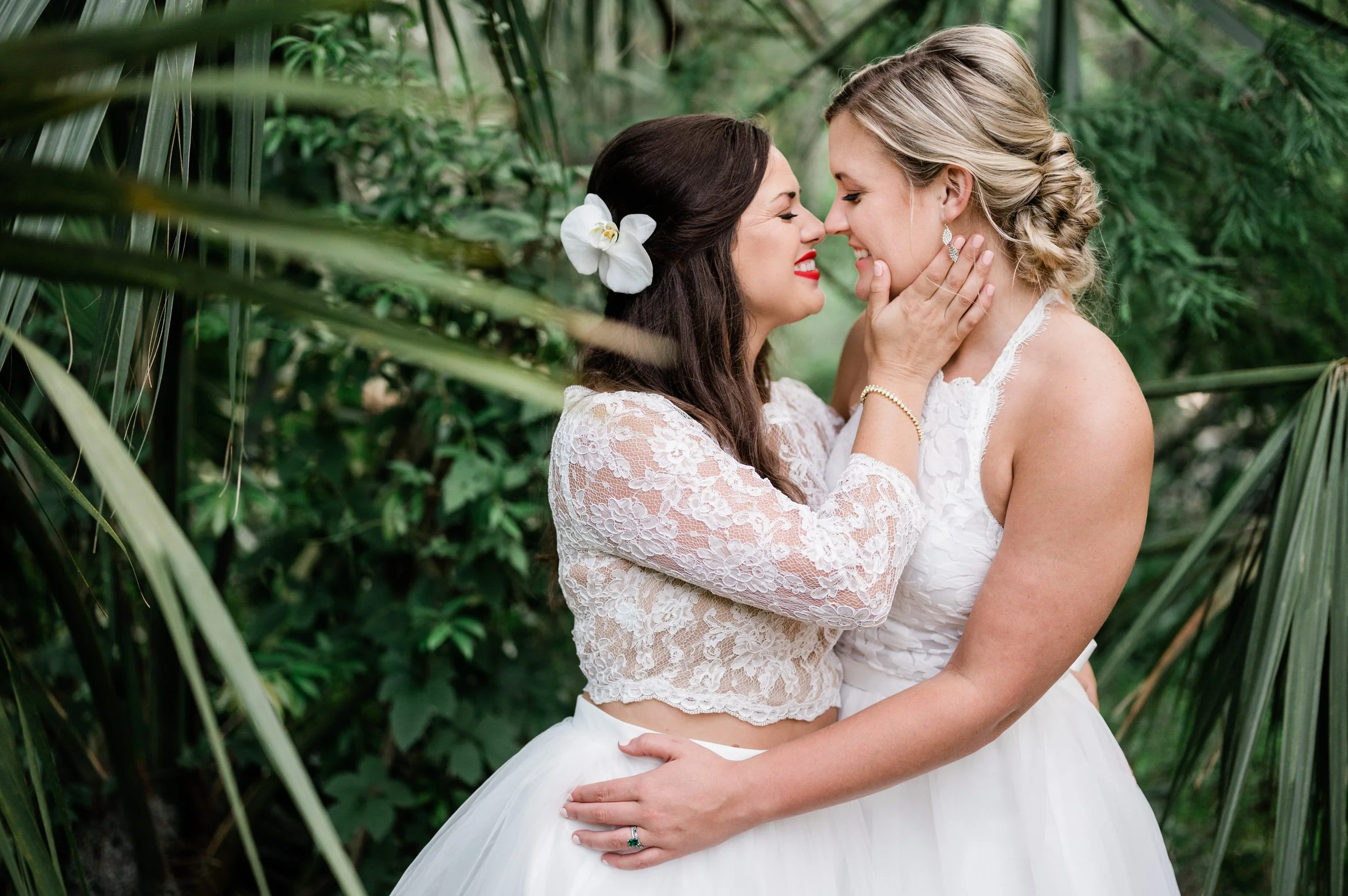 Newlyweds smiling with their arms around each other as they lean in to kiss