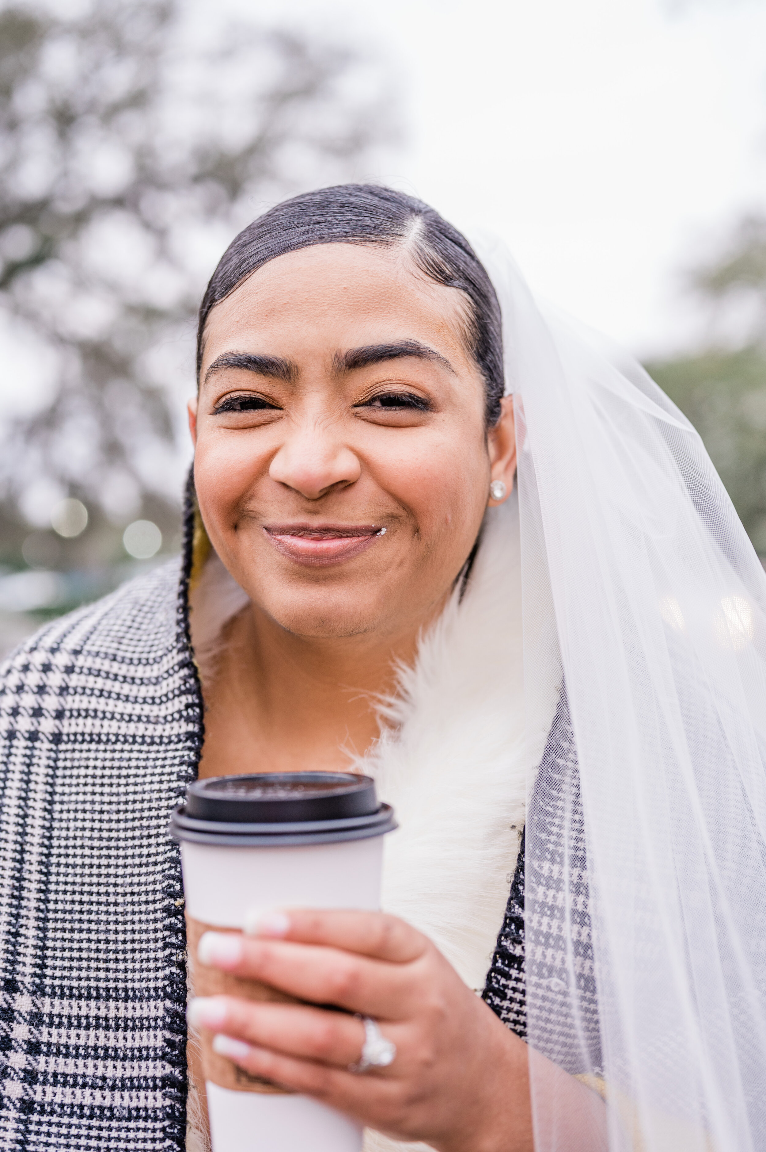 The bride smiles with coffee in her hand and powdered sugar on her face