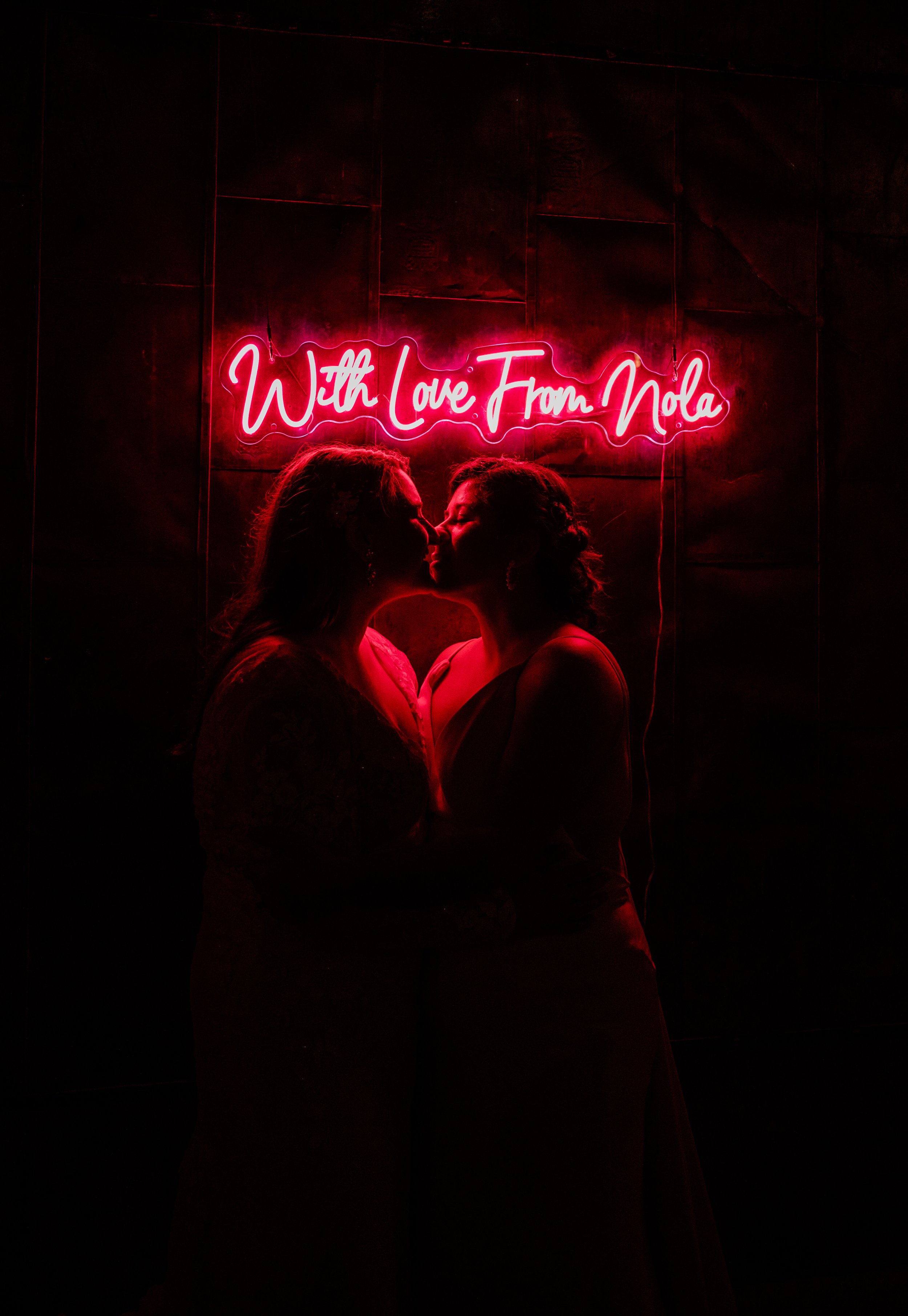 Brides kiss in the neon light