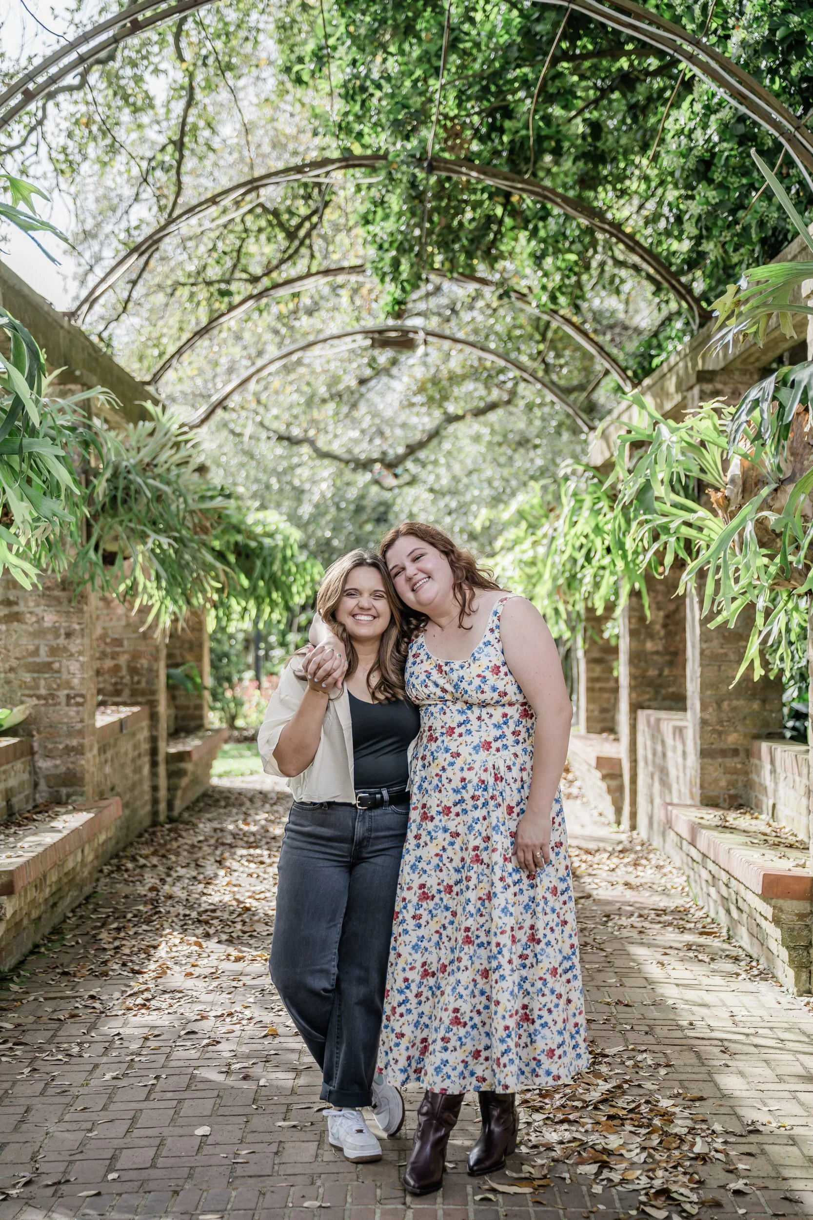A person with their arm around their partner's shoulder as they lean into each other and smile