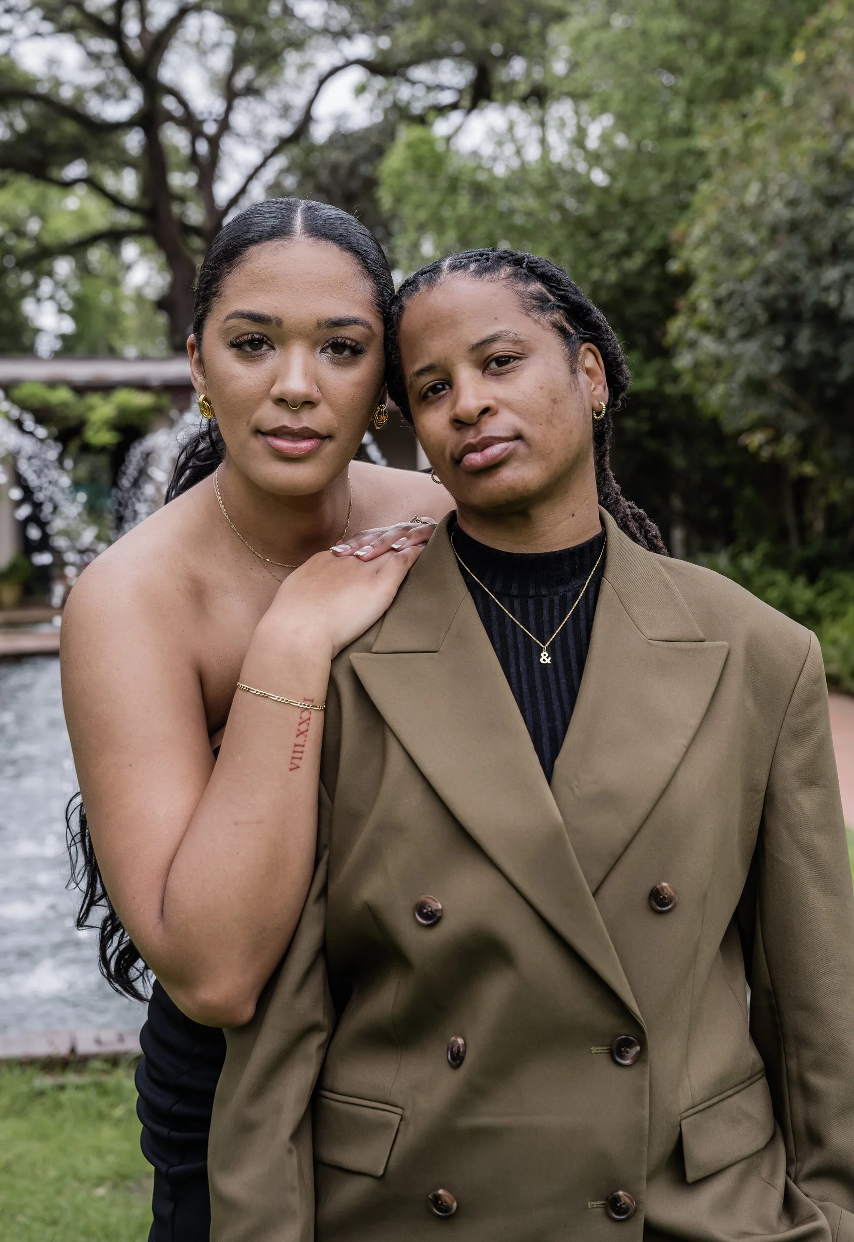 A person standing behind their partner and resting their arms on their shoulder