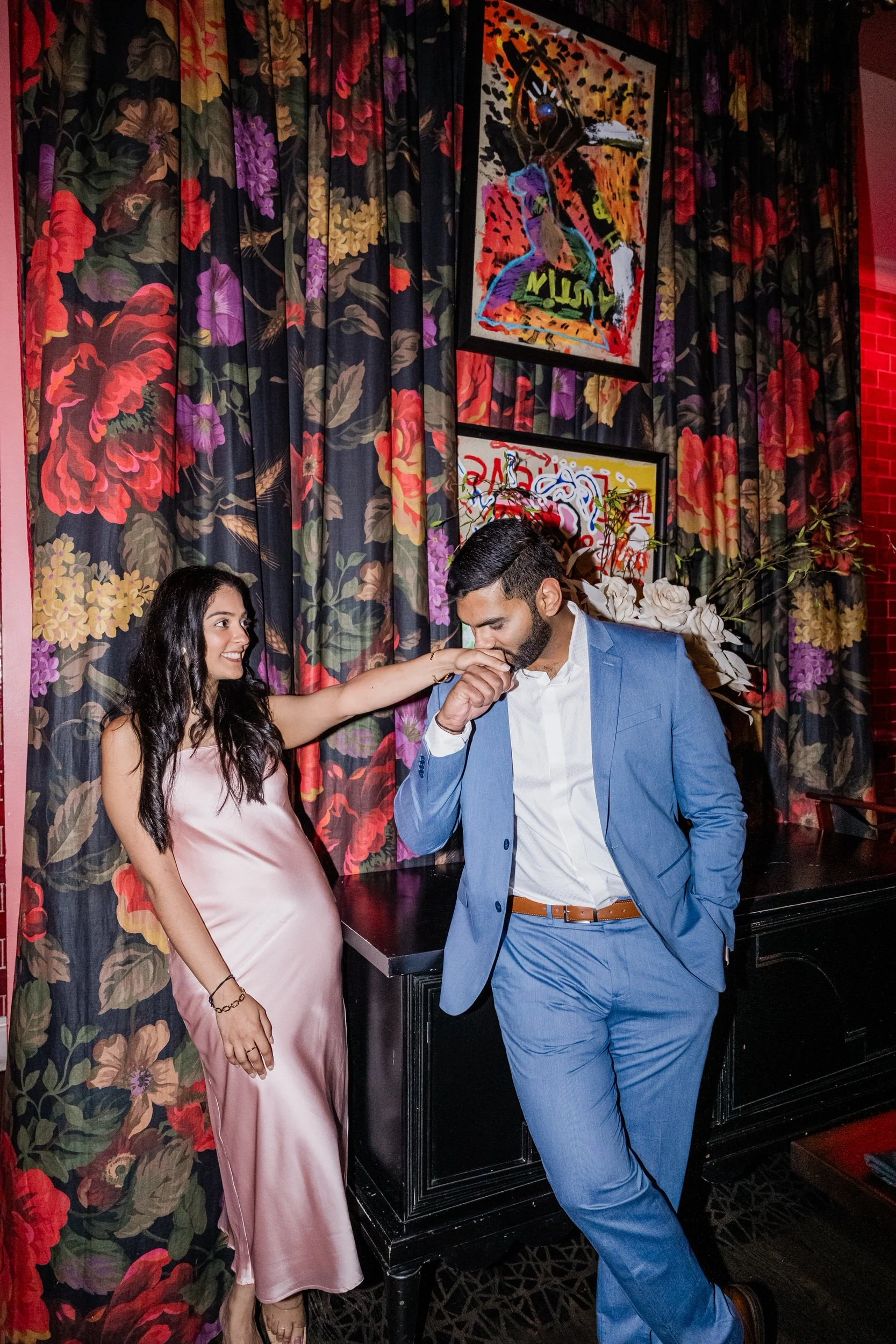 A person standing next to their partner as they kiss their hand