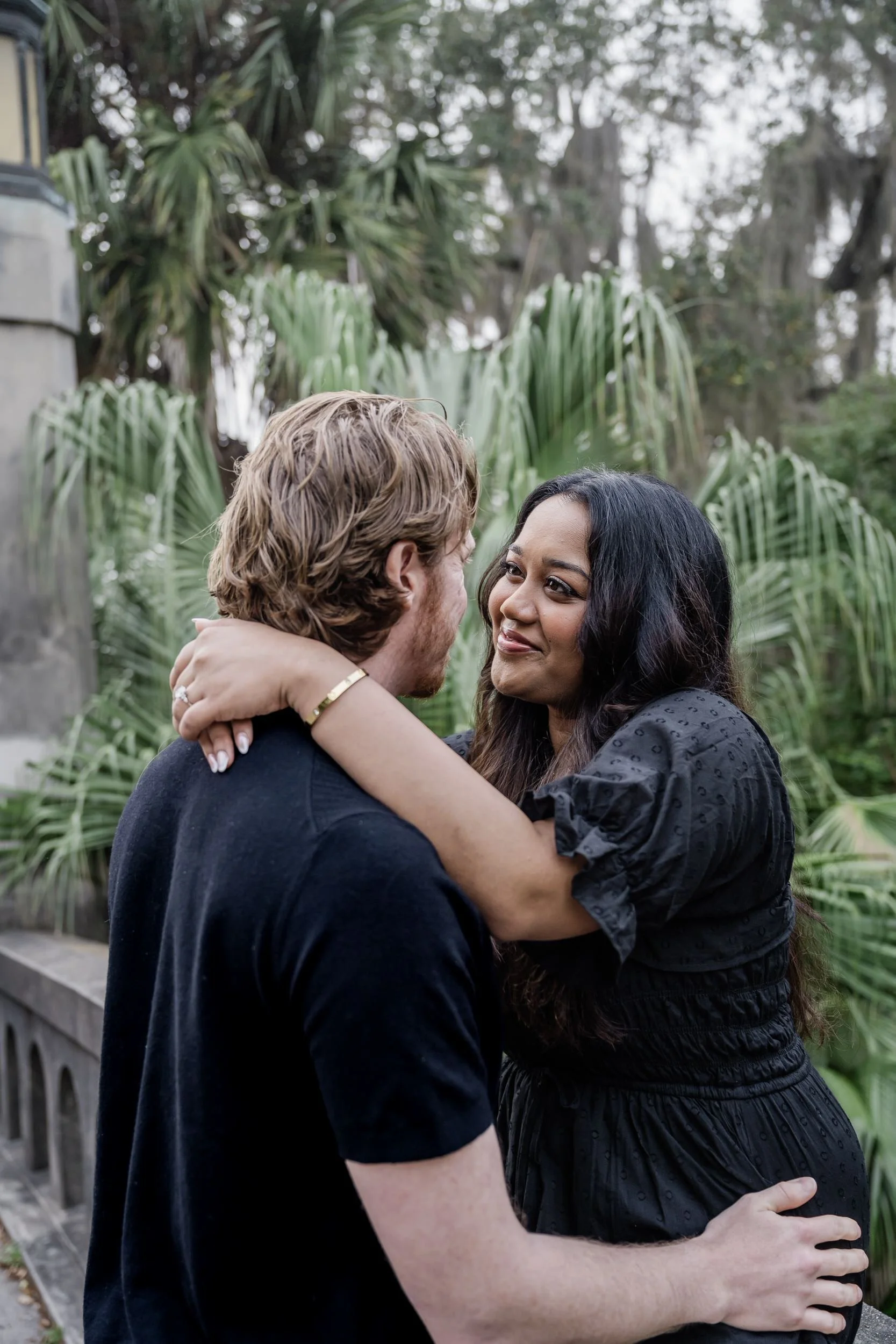 A couple in a garden with their arms around each other smiling