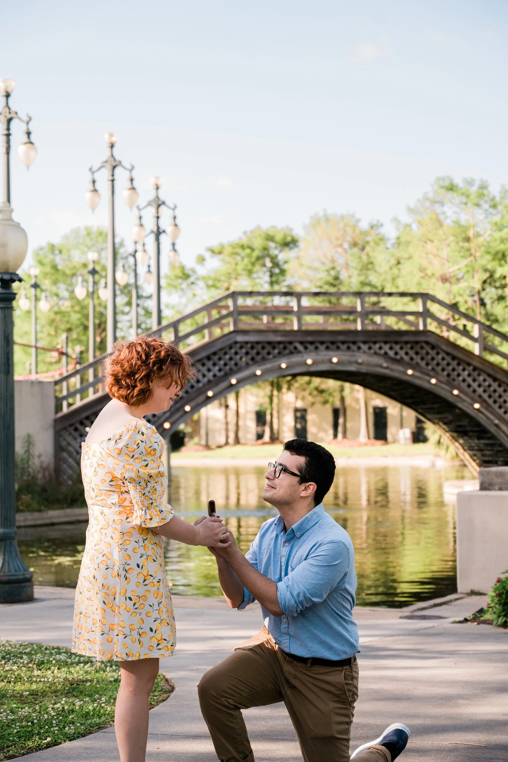 A person proposing to their partner on the edge of a lake