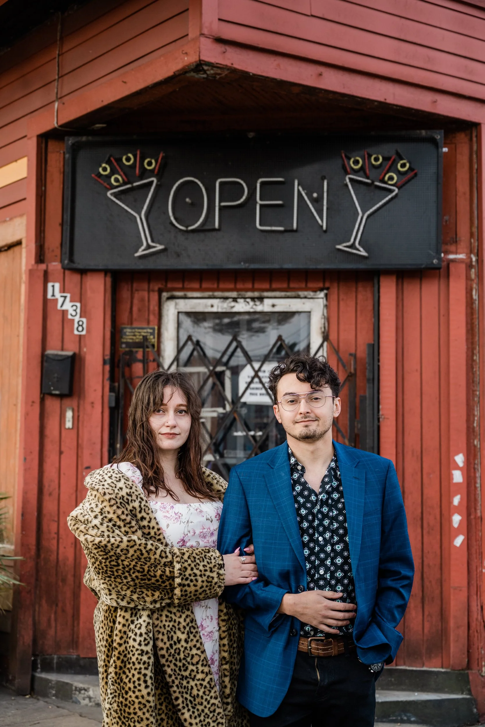 A couple standing arm in arm together outside of a restaurant