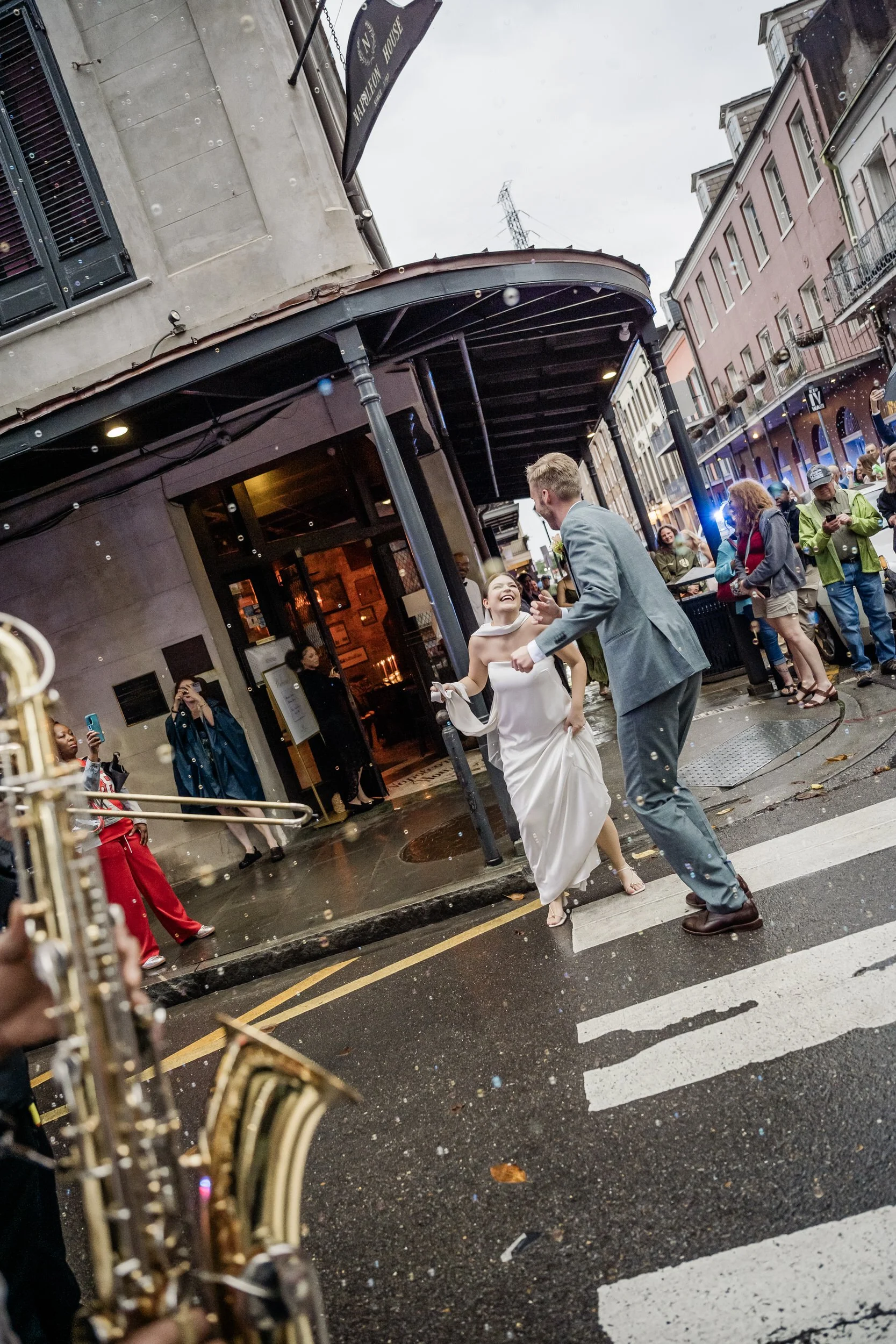 A couple dancing as they walk across a crosswalk after their wedding 
