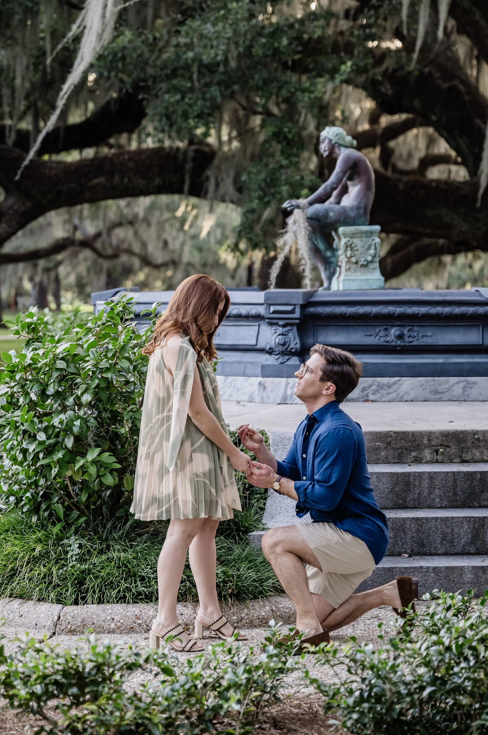A person kneeling down and holding their partner's hand as they propose