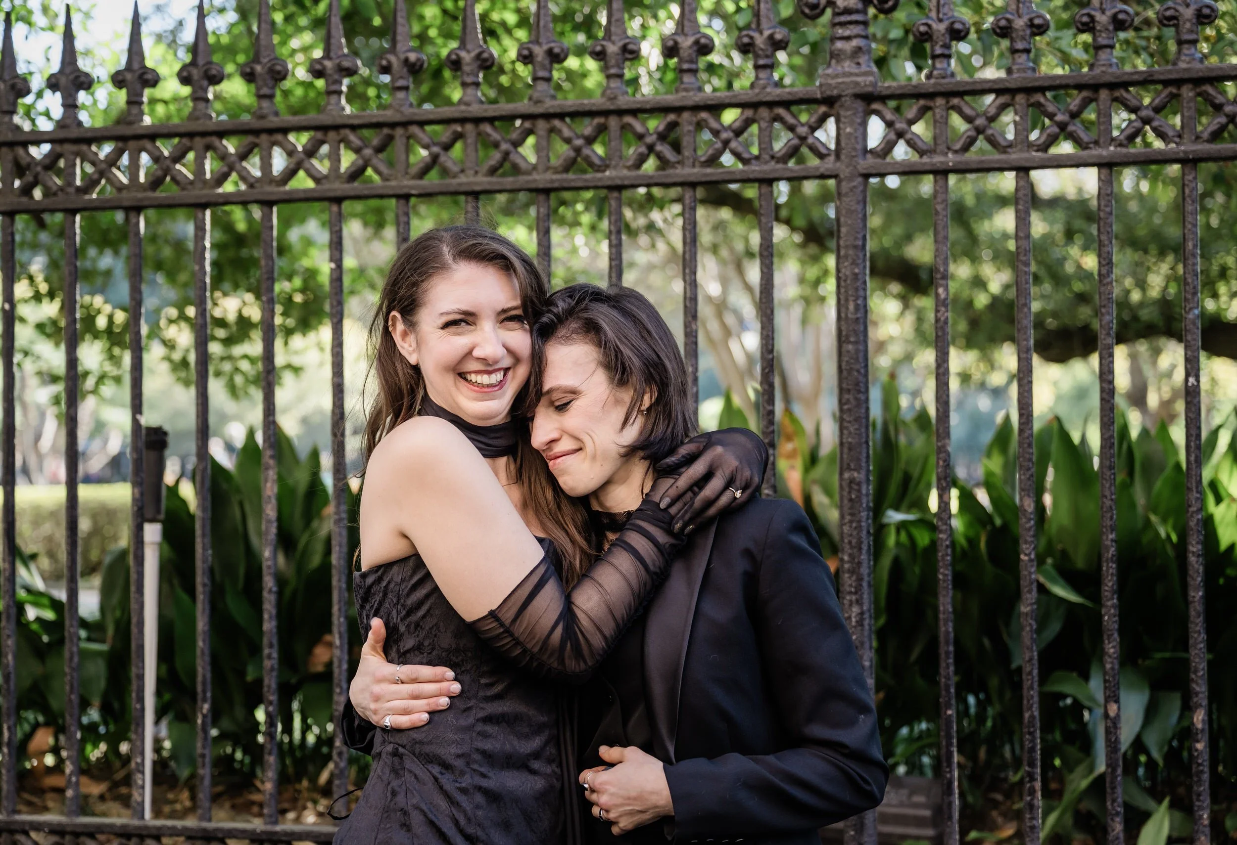 A couple standing next to each other hugging as they both smile