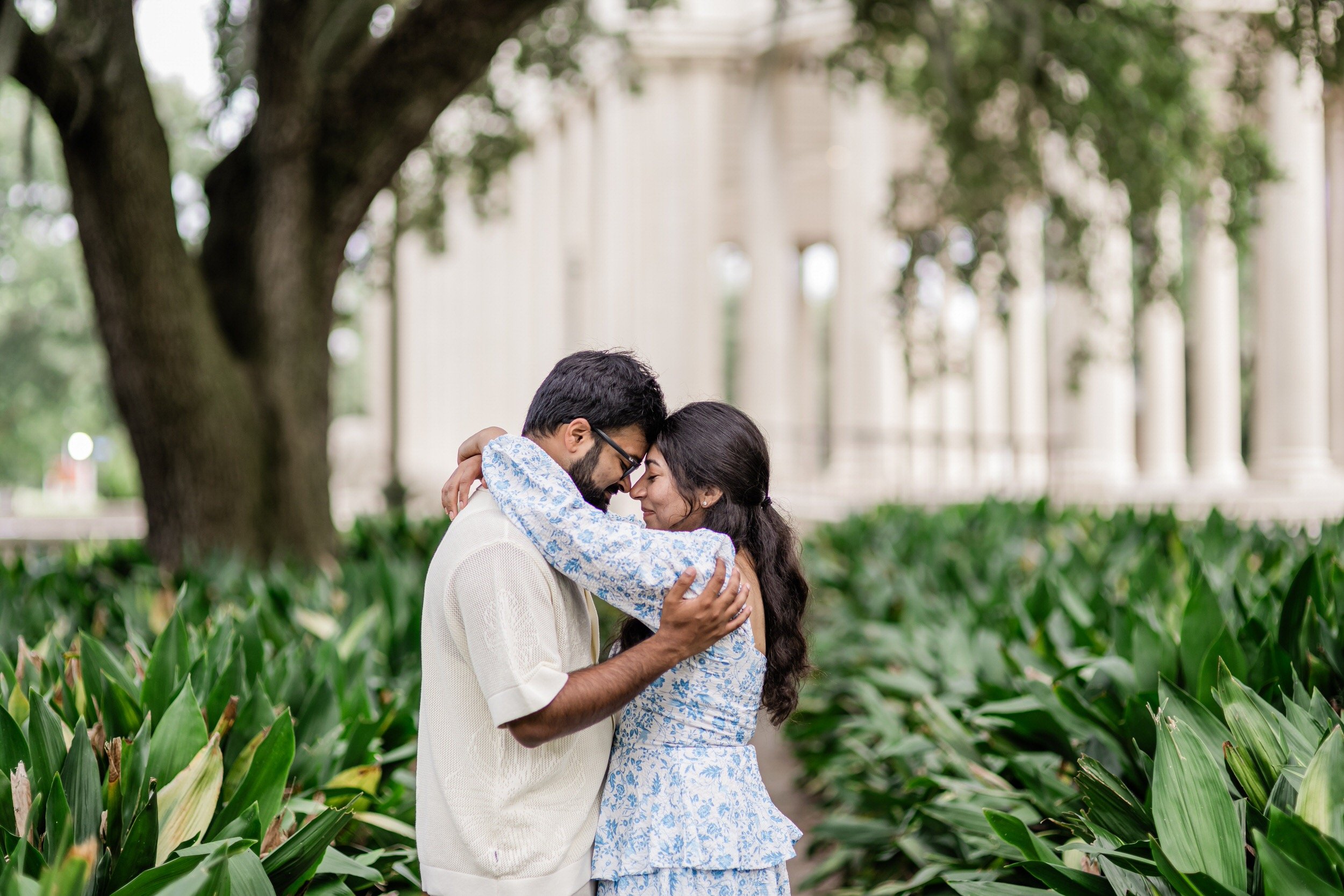 A couple standing forehead to forehead with their arms around each other