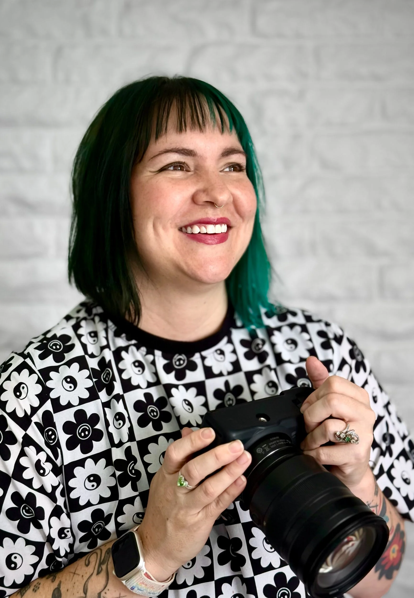 Ash smiling while holding a camera