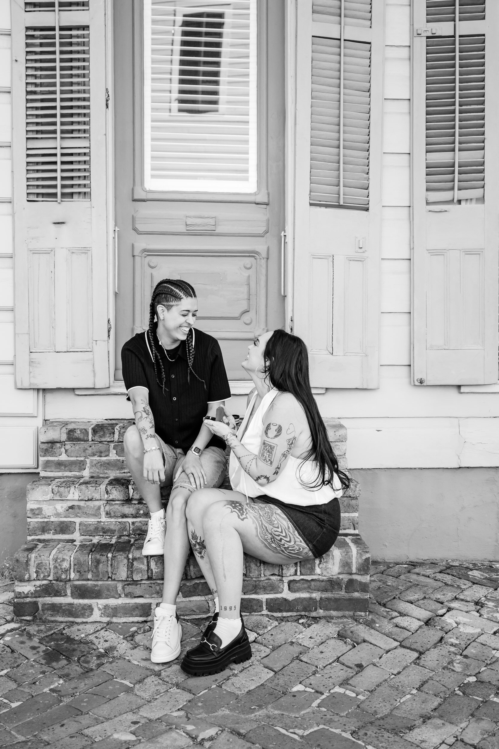 A couple sitting on a brick staircase laughing together