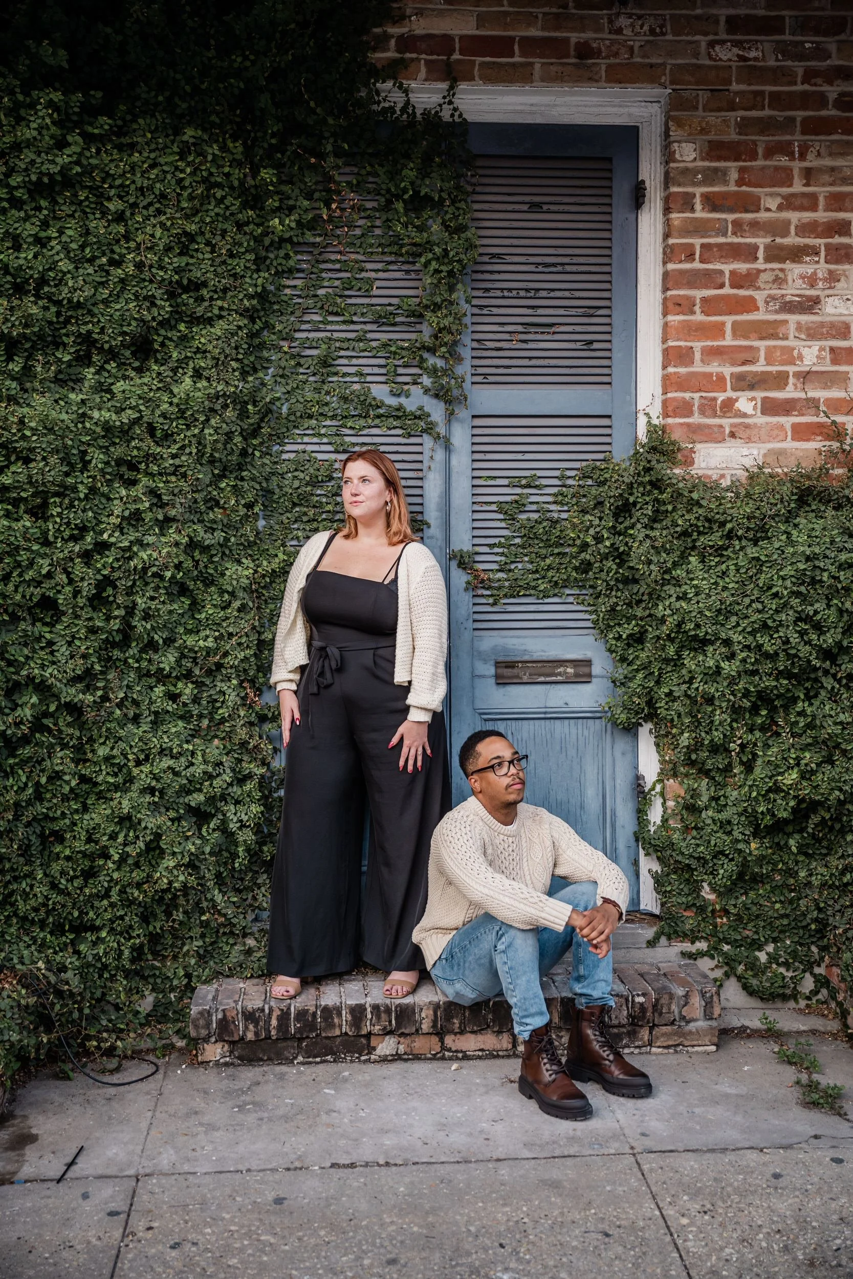 A person sitting on the ground next to their partner as they look opposite directions