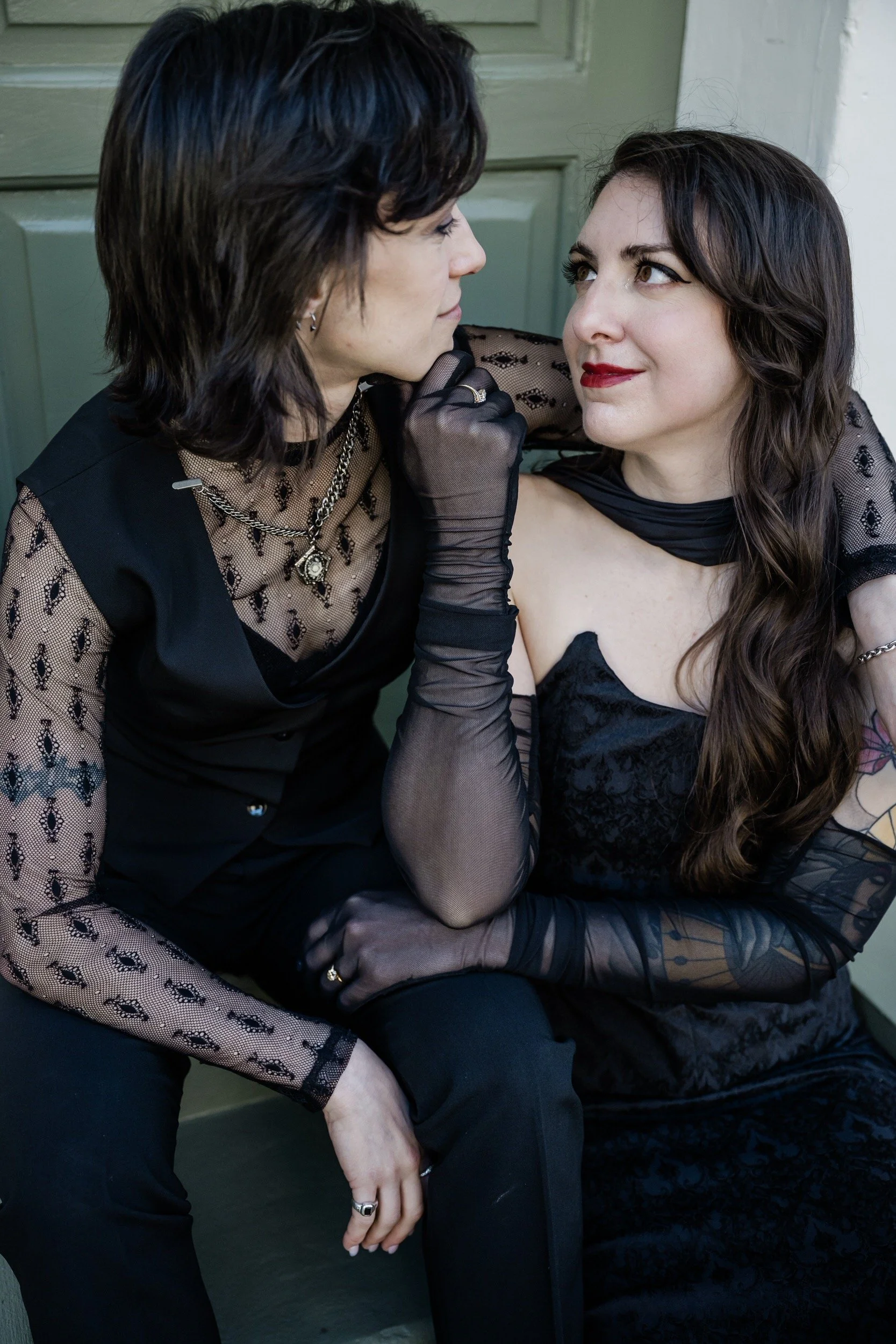 A person with their arm around their partner's shoulder as they look at each other
