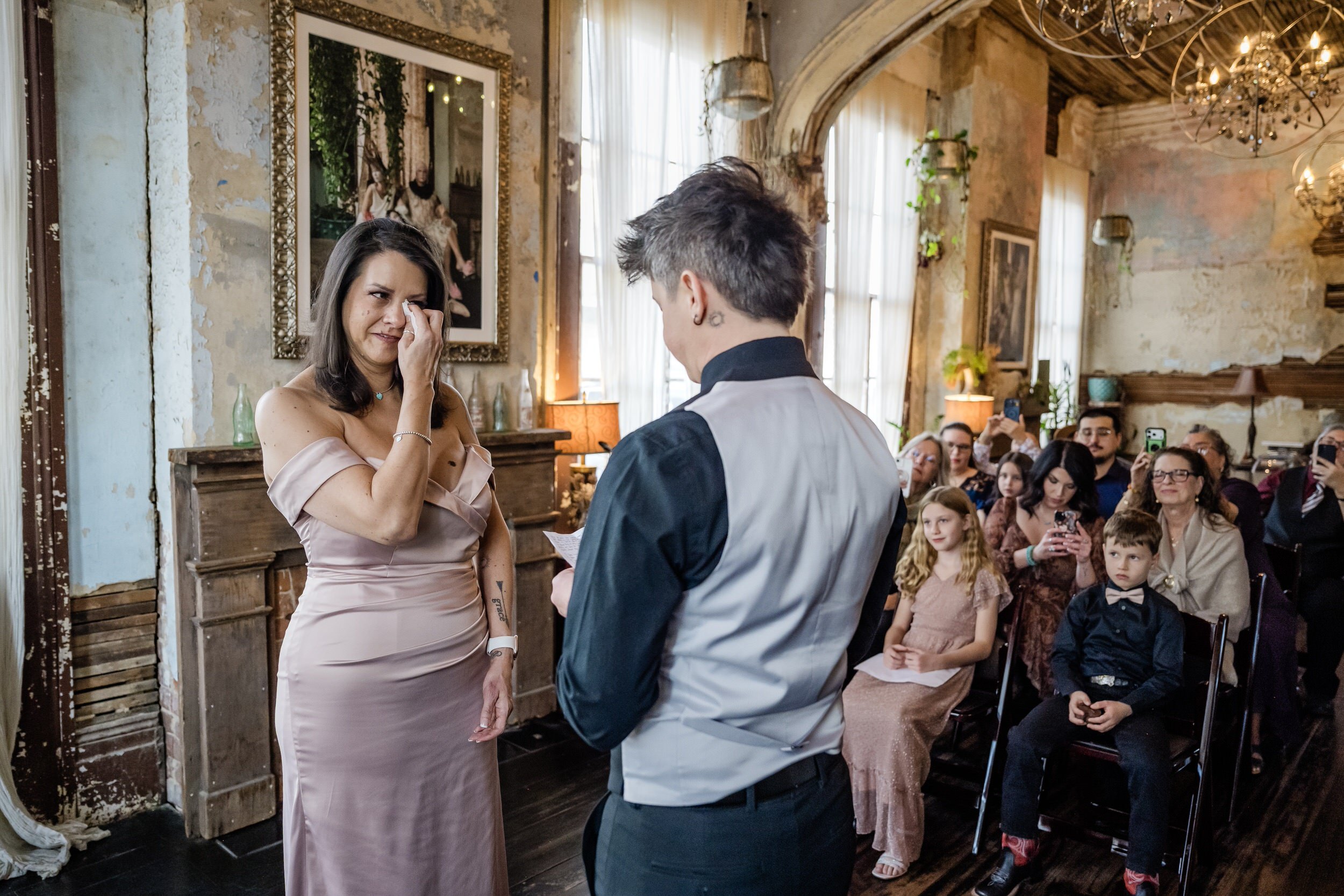 A couple reading vows during their elopement while one wipes away tears