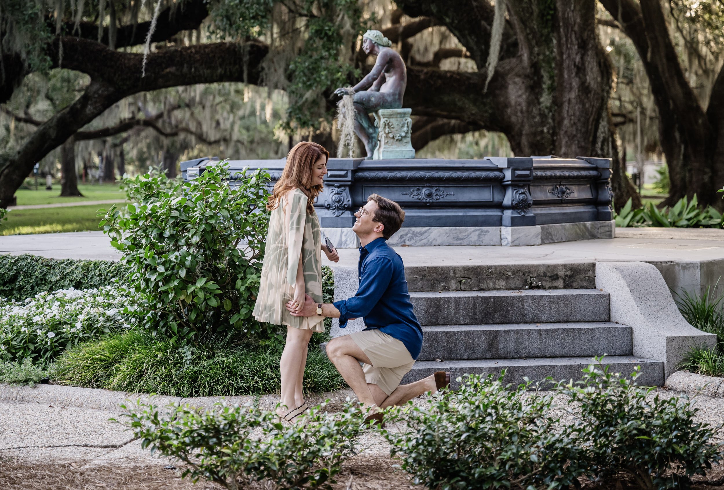 A person holding their partner's hand as they kneel down and propose