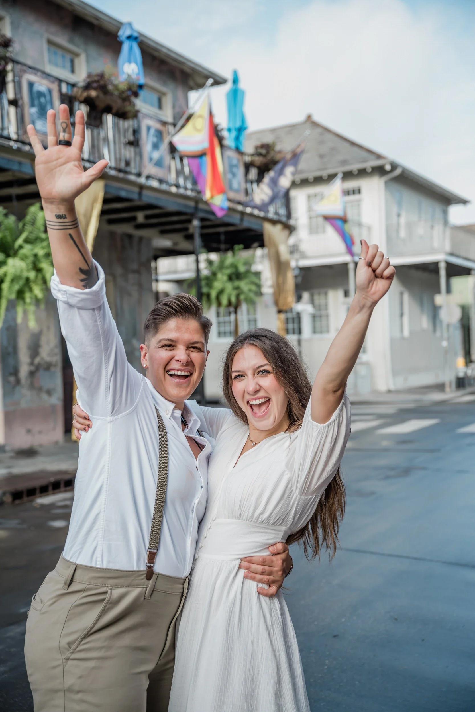 Newlyweds with their arms up celebrating in the street