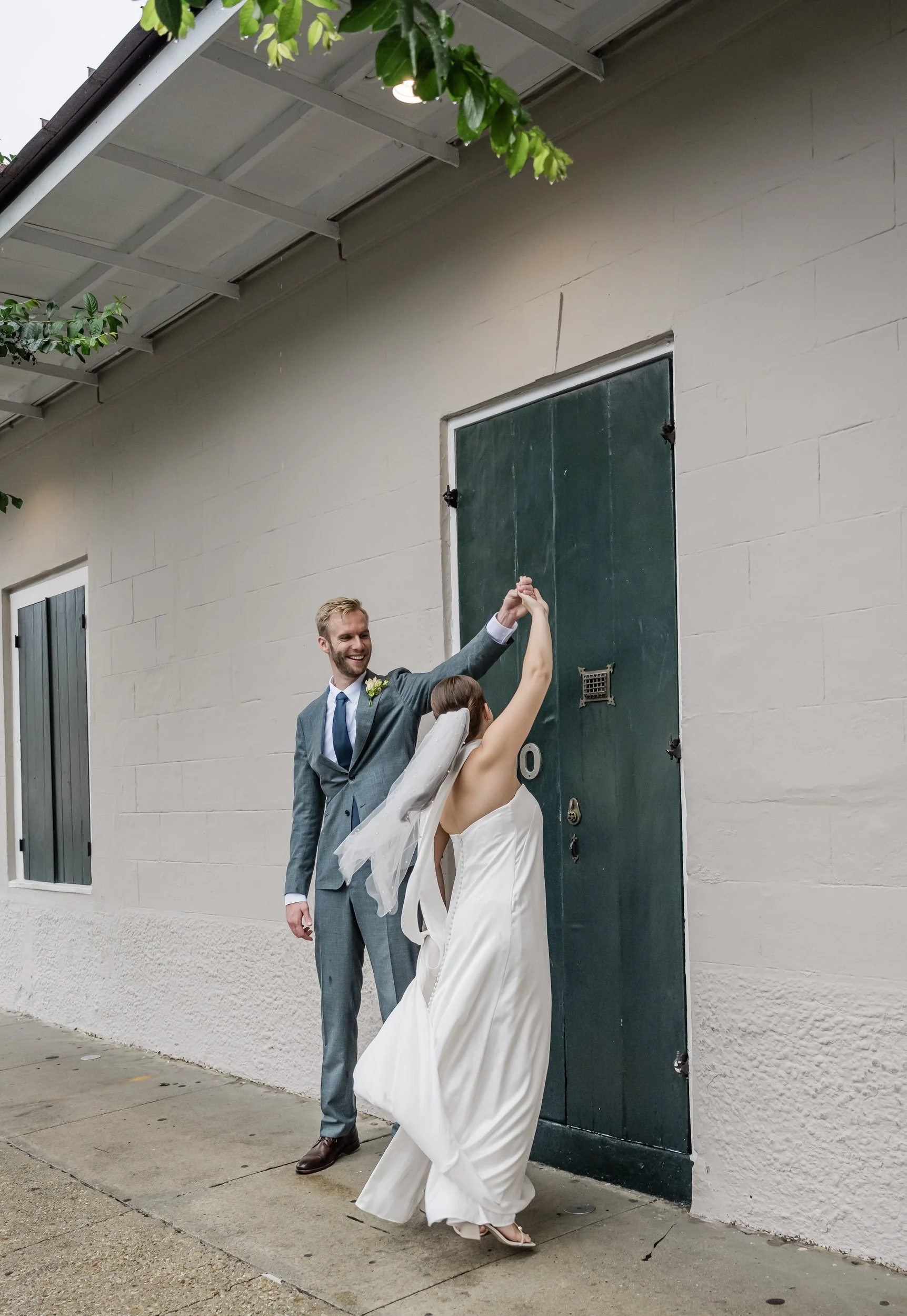 A newlywed couple dancing on a small sidewalk