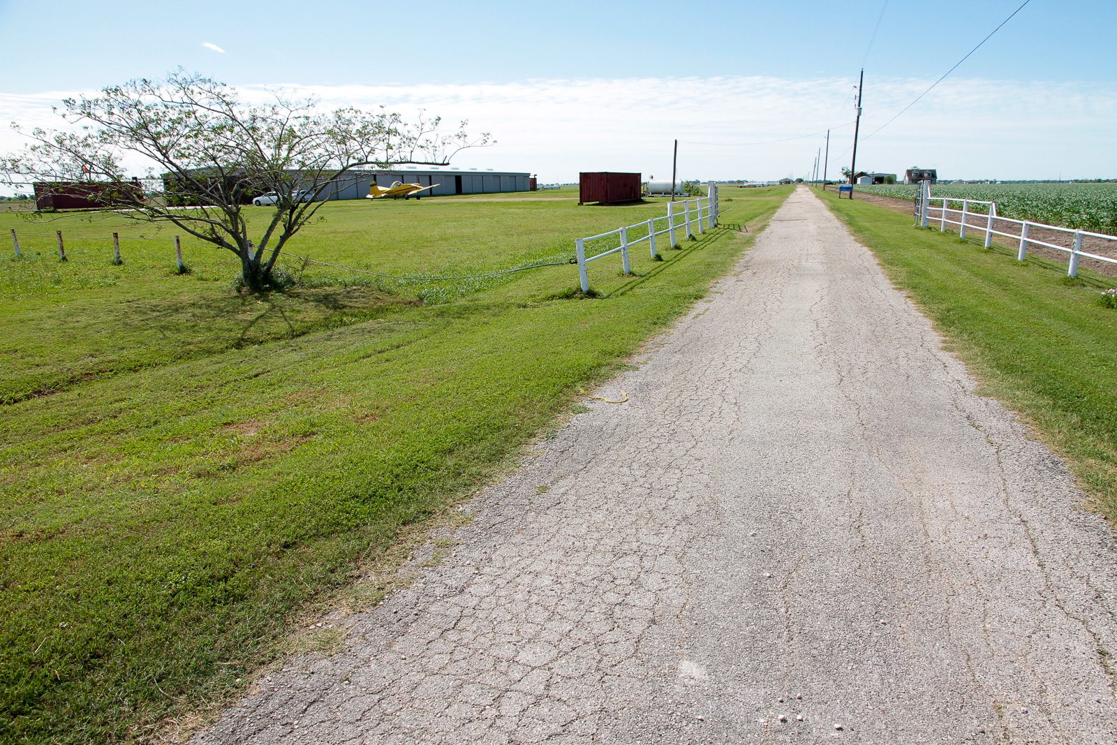 Look for the white hangar on the south side of Highway 36 just east of the Brazaos High School just east of Wallis. Turn south on Gibbs Road.
