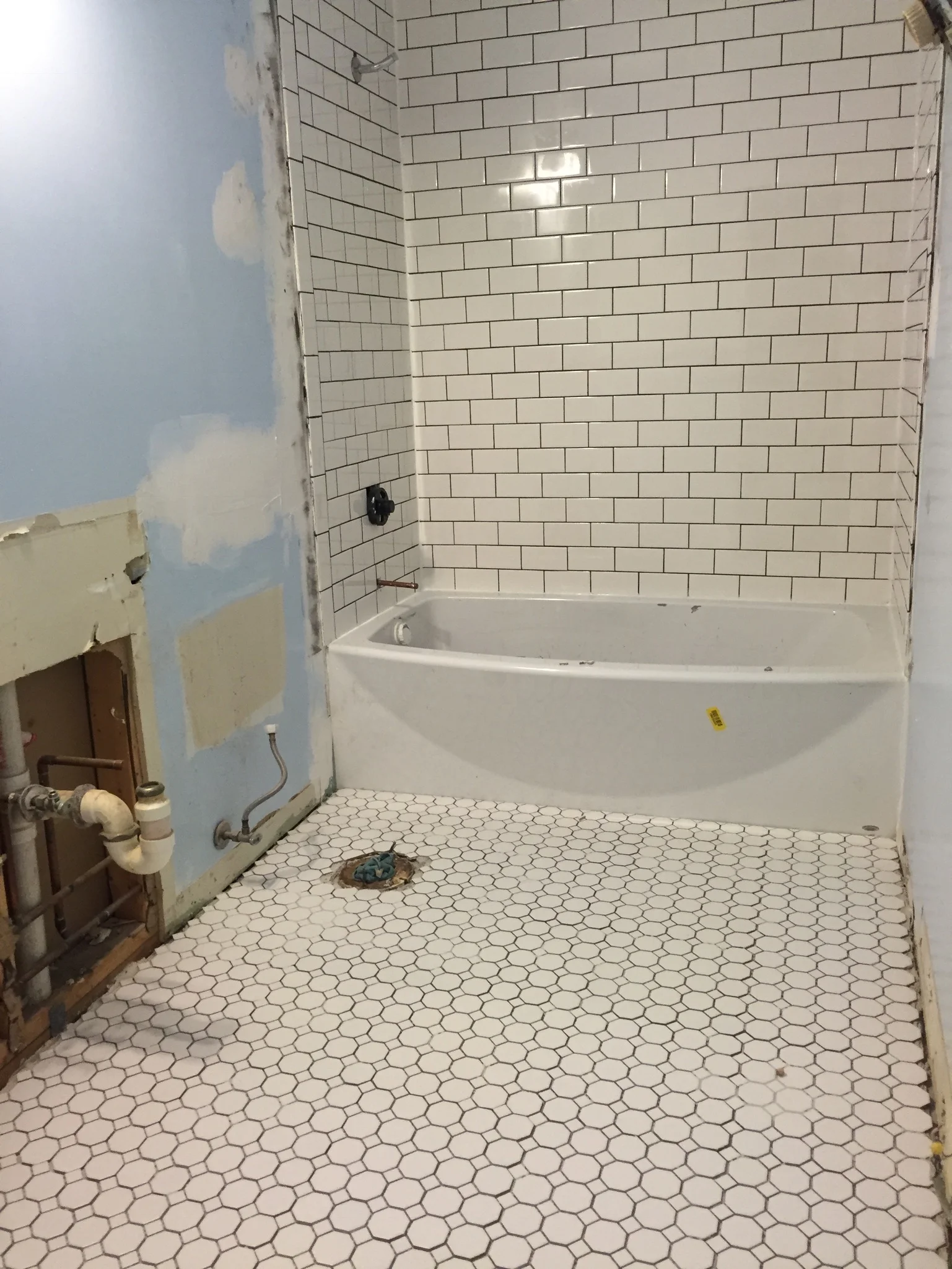 Added hexagon floor tile and subway tile with charcoal gray grout. Removed closet and plumbed for double vanity.