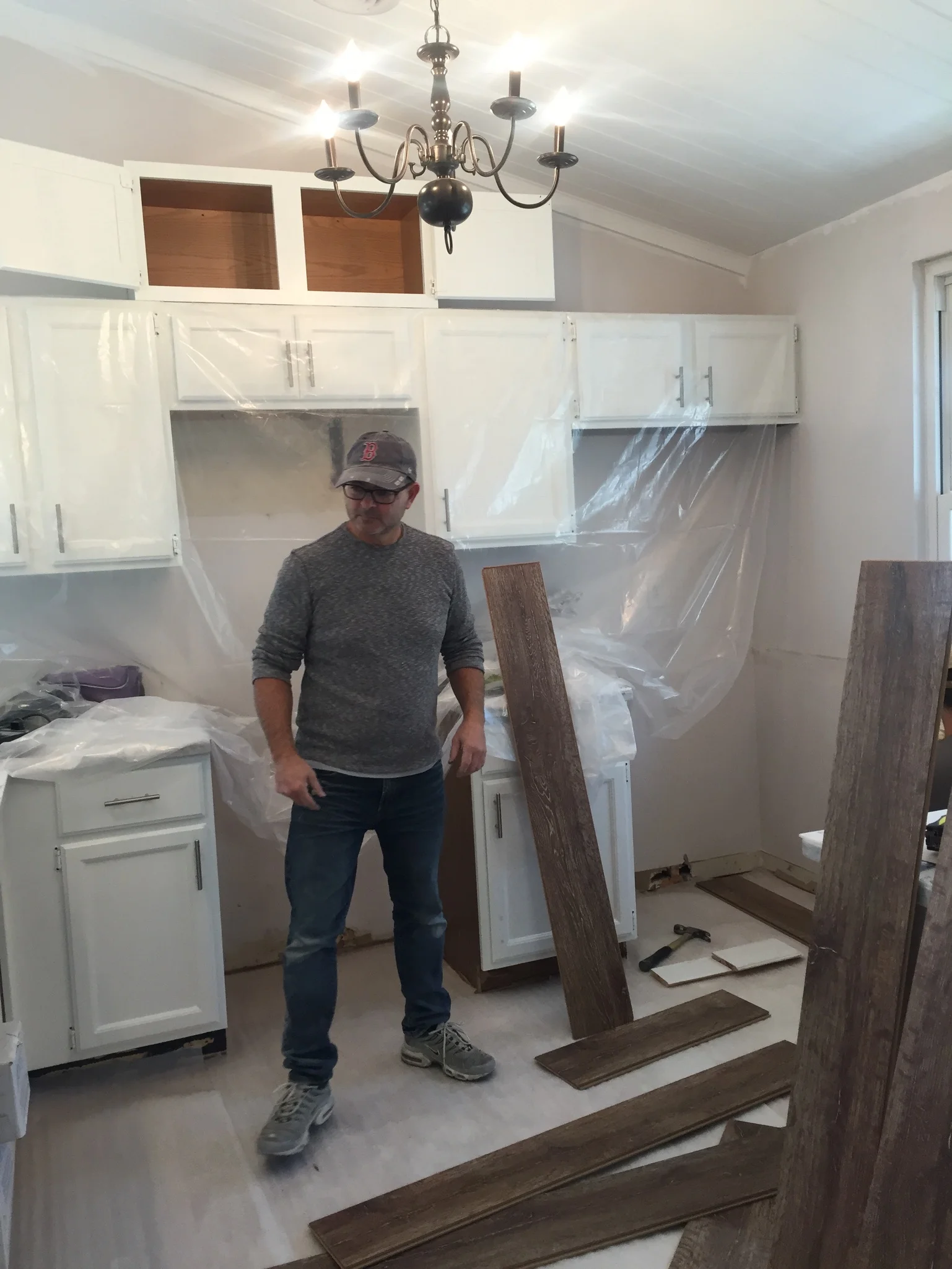 Added vinyl flooring (Quick Step) and new hardware on cabinets. Painted the chandelier that was hanging in our dining room and hung it here. 