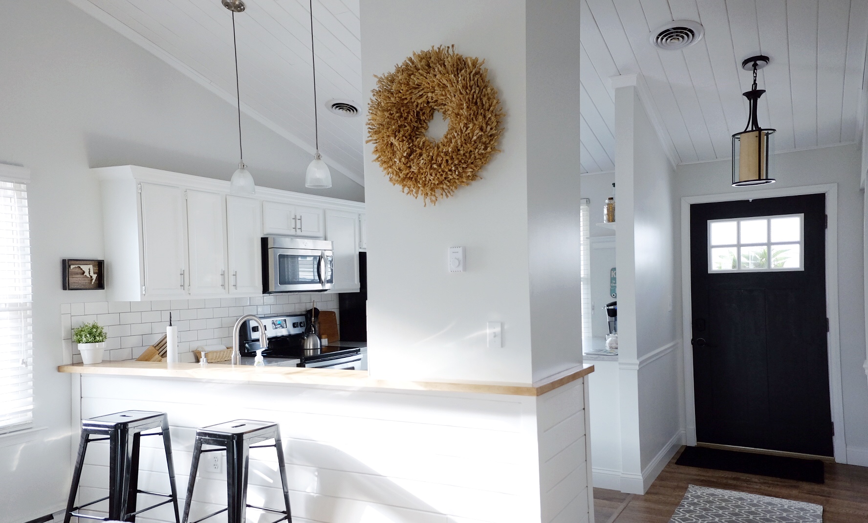 barstools: Marshalls; door paint: tricorn black SW 6258; wall color: drift of mist sw 9166; wreath: homegoods; lights: lowe's