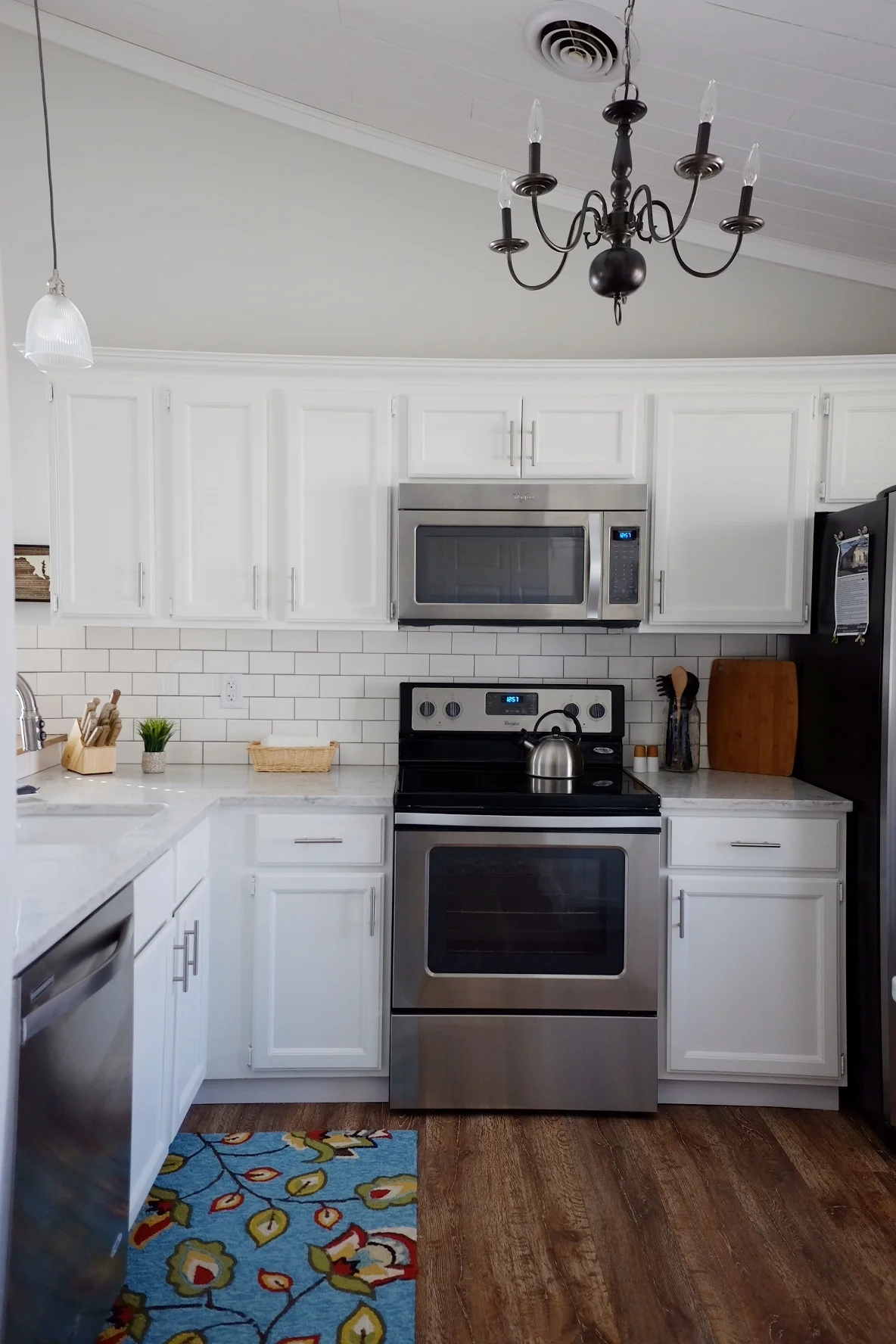 Paint: Valspar cabinet paint -pure white (semi-gloss), rug: TJ MAXX, Chandalier: Home Depot (spray-painted black); pendant lights: lowe's; backsplash: white subway tile w/DeLorean Gray grout)